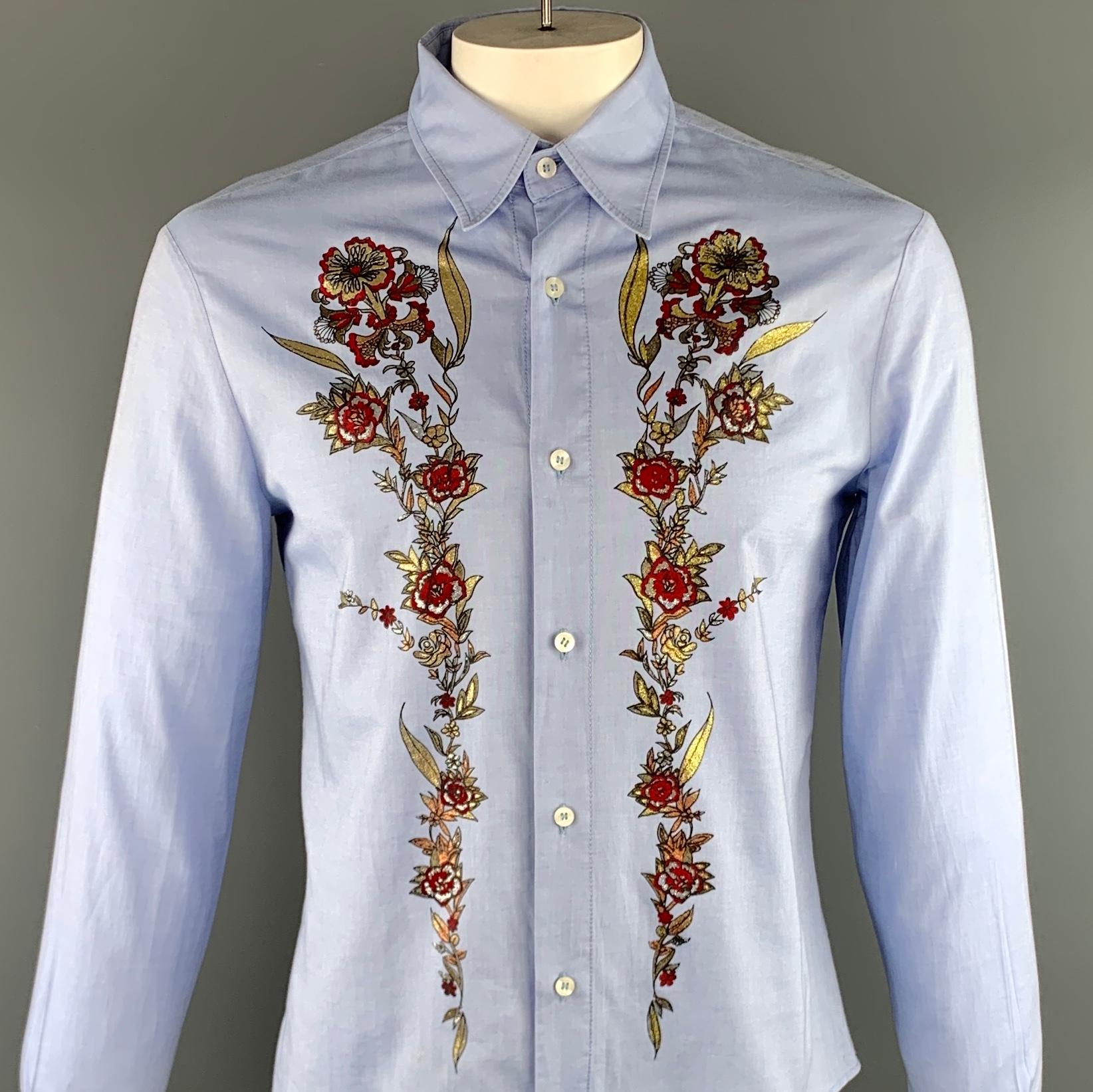 JUST CAVALLI long sleeve shirt comes in a light blue cotton featuring a red and gold front floral embellishment, button up style, and a spread collar. Minor discoloration. Made in Romania.

Good Pre-Owned Condition.
Marked: