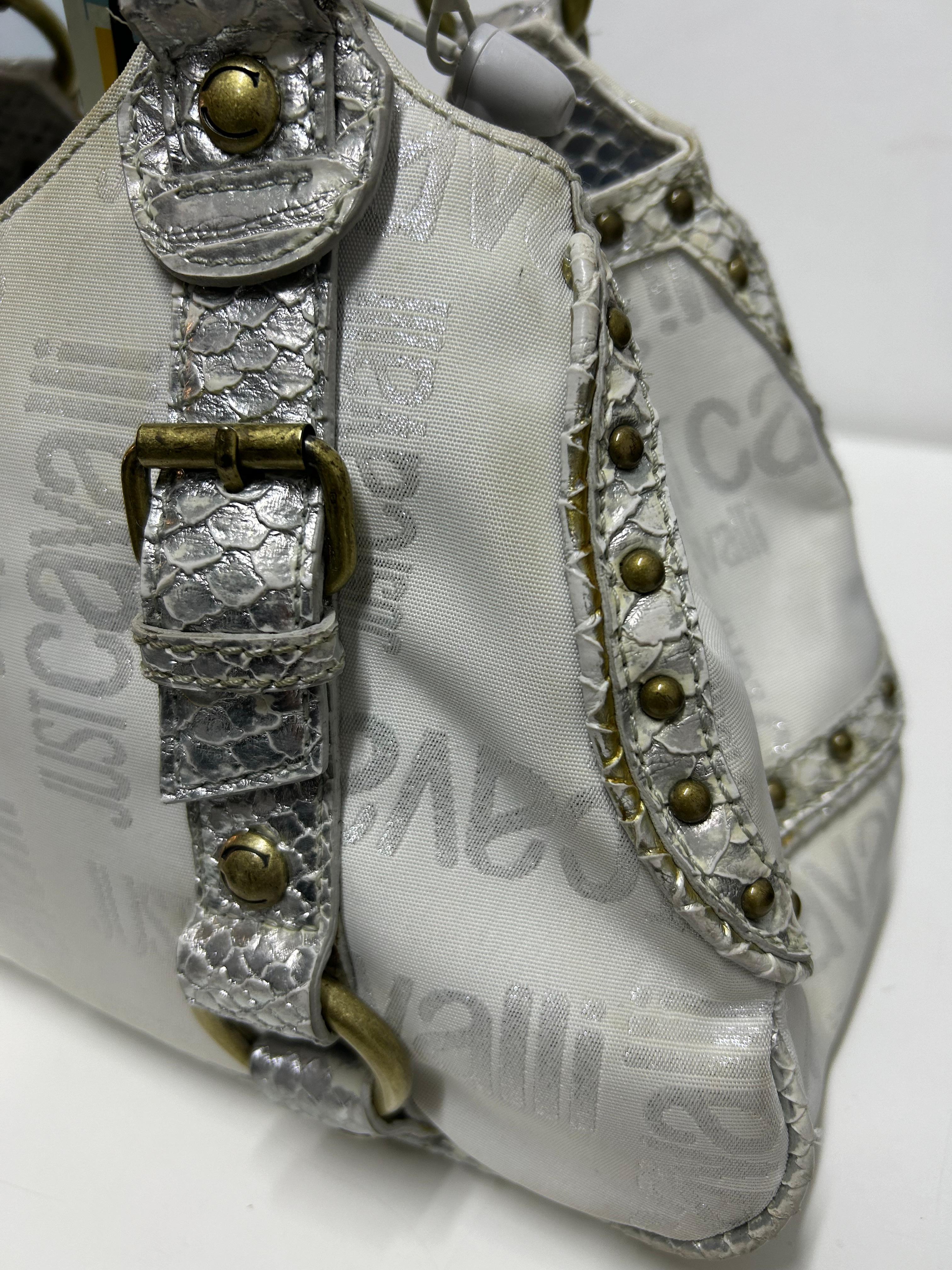 Add a touch of bold Italian glamour to your wardrobe with this Just Cavalli White Embossed Leather Satchel. Crafted from glossy embossed leather with tonal logo detailing, this structured satchel features braided top handles, metallic snake-effect