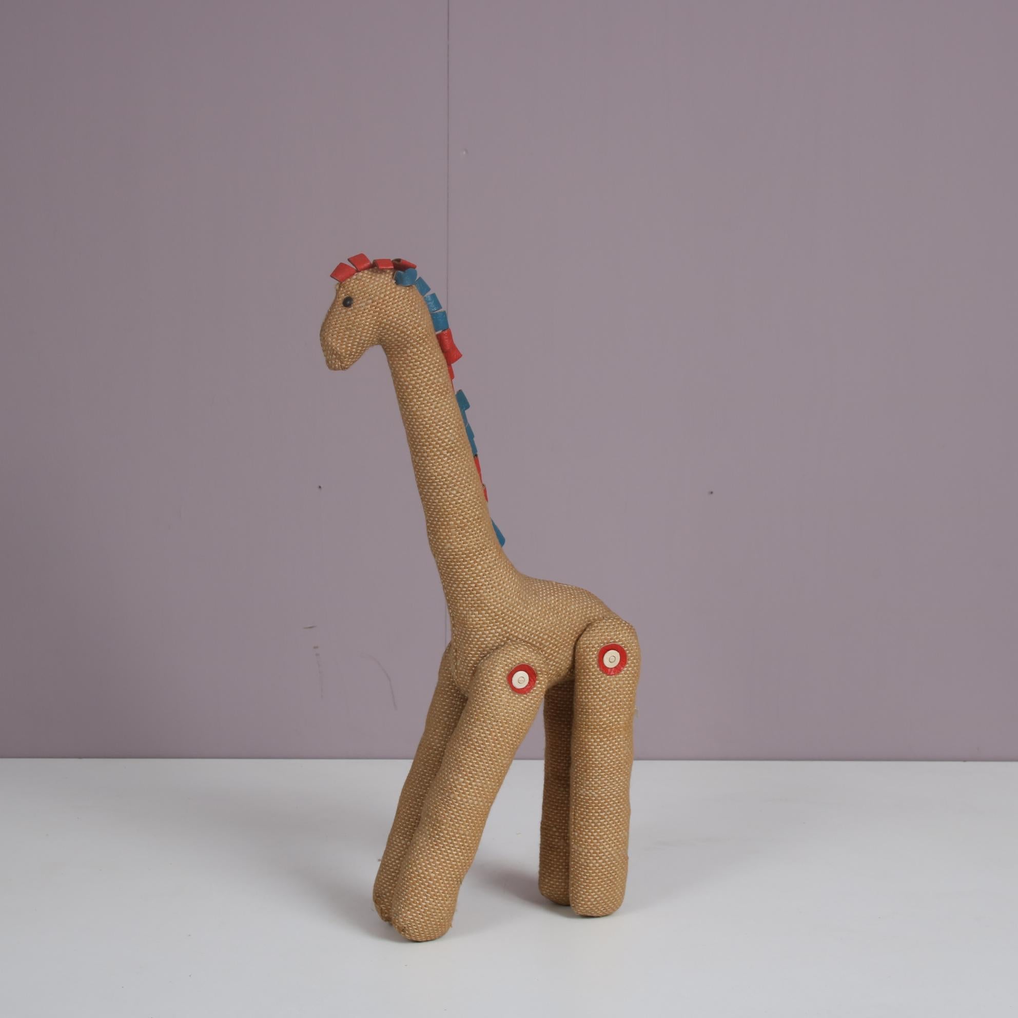 A rare therapeutic toy giraffe designed by Renate Müller, manufactured by H. Josef Leven Kg in Germany around 1960.

Made of high quality jutte and coloured (red and blue) leather, this piece has a beautiful and playful appearance which makes it a