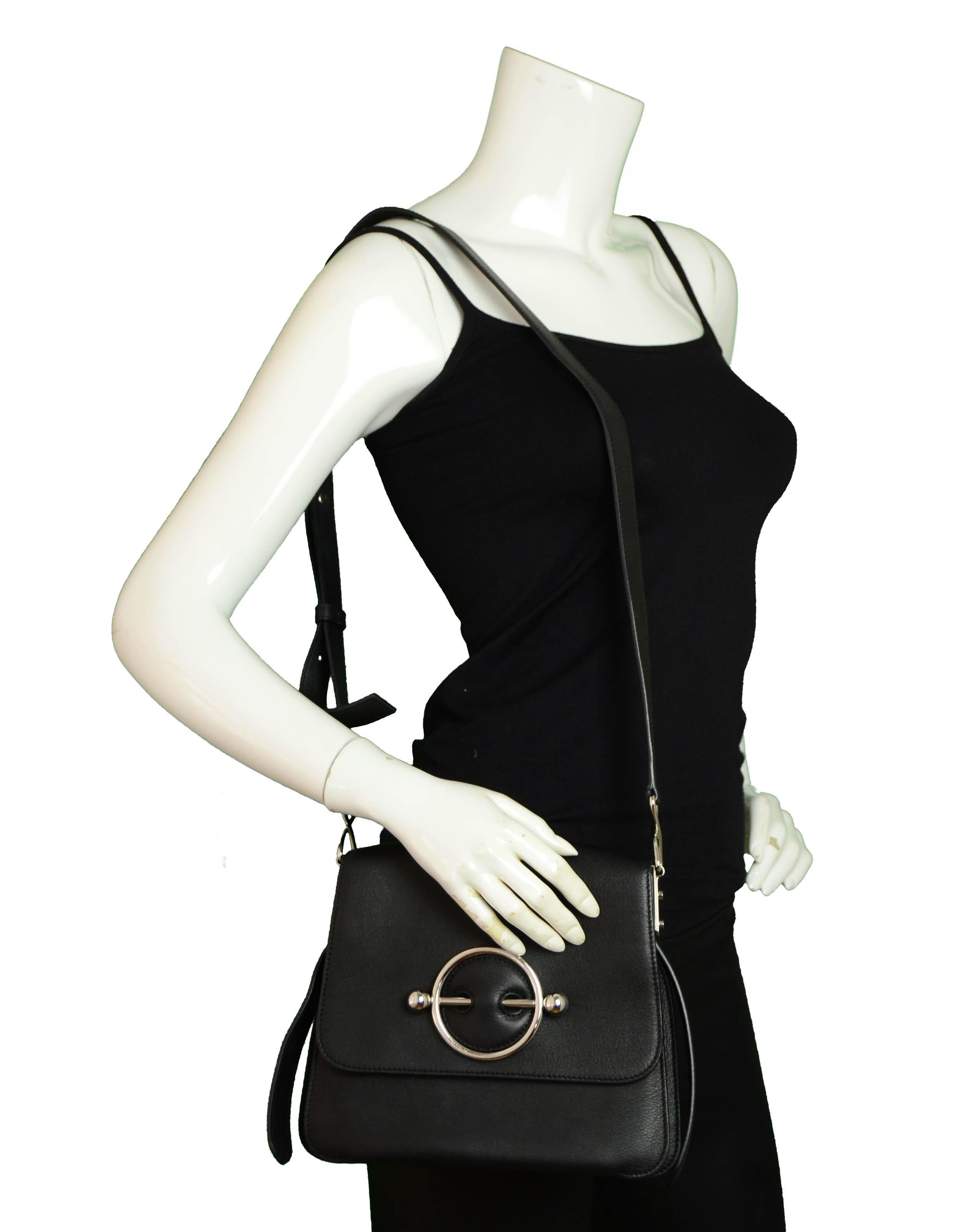 J.W. Anderson Black Leather Silver Disc Crossbody

Made In: Spain
Color: Black
Hardware: Silvertone
Materials: Leather
Lining: Beige suede
Closure/Opening: Flap top with magnetic snap
Exterior Pockets: One zipper pocket at back
Interior Pockets: Two