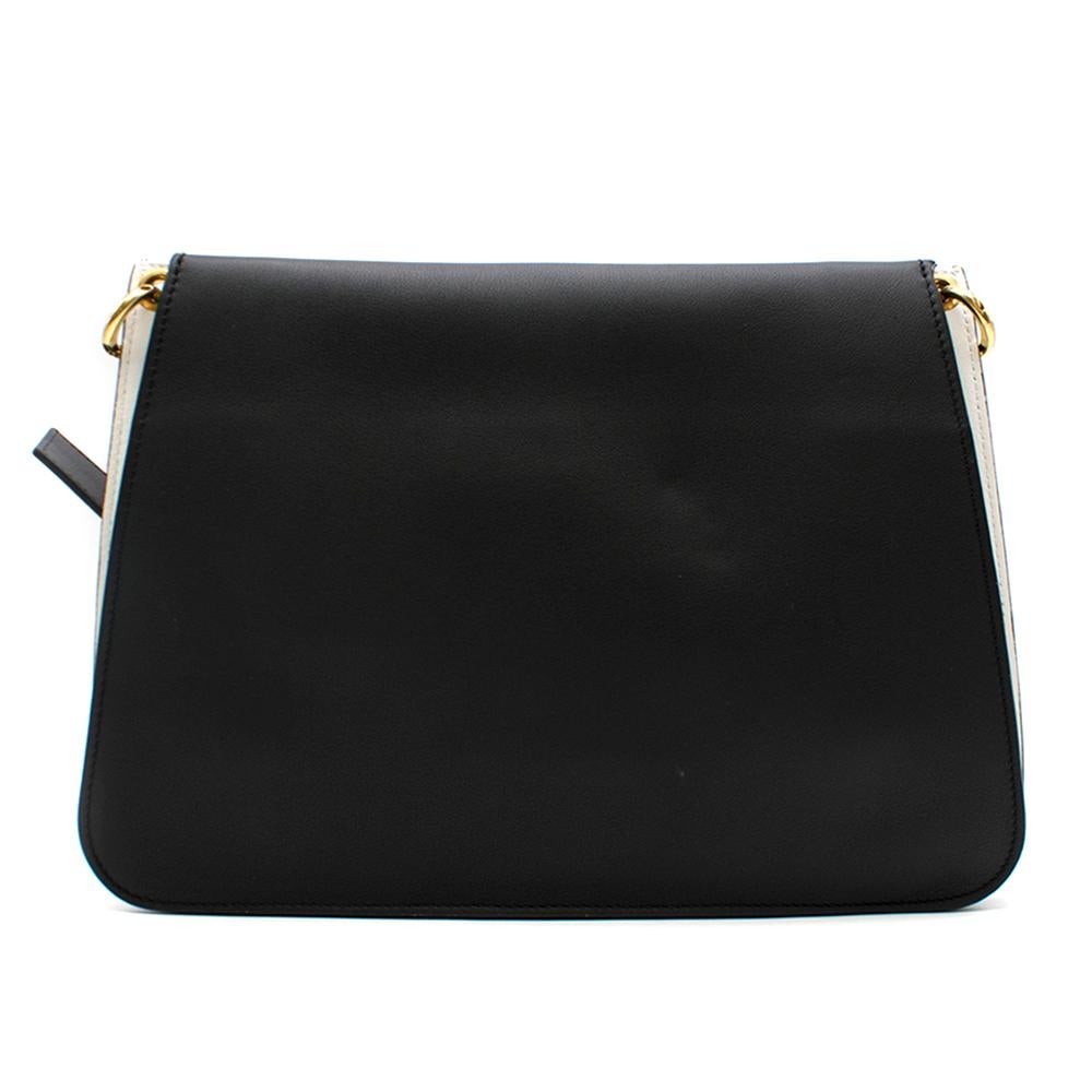 J.W. Anderson medium leather shoulder bag in black and white. Made of calf leather. Features a front flap, adjustable, detachable shoulder strap and striking gold-tone hardware including the designers signature ring detailing

- Made in Spain
-