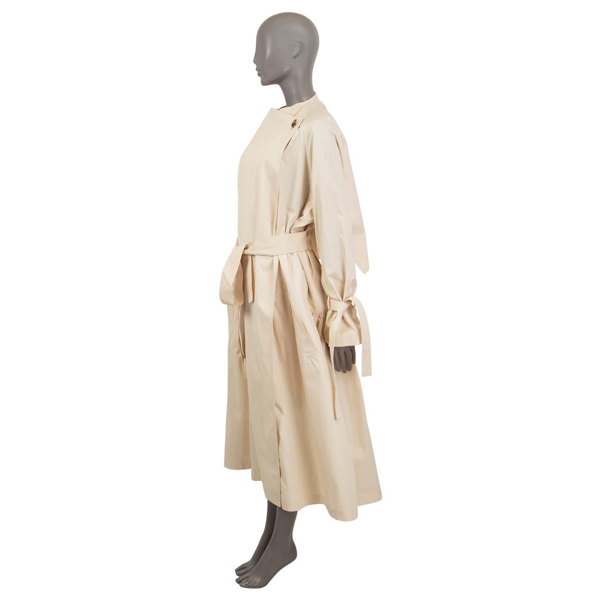 100% authentic J.W. Anderson one button oversized trench coat in cream cotton (100%). Features long raglan sleeves (sleeve measurement taken from the neck) and knotted cuffs. Has two side pockets and a detachable belt with an embroidered logo. Opens
