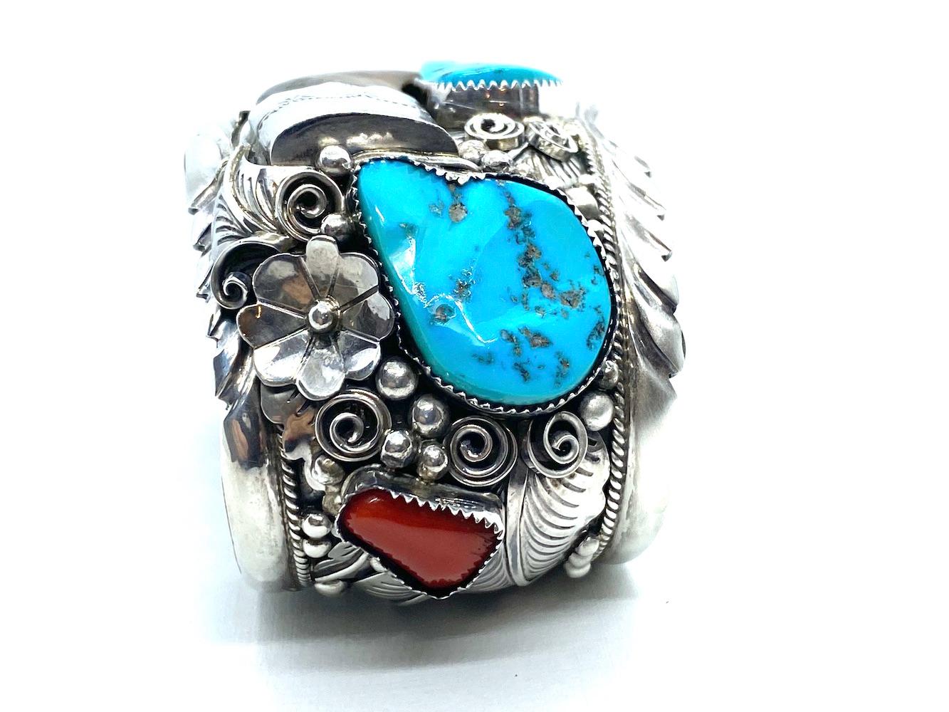 Made made and intricately designed cuff bracelet features a large bear claw. The surrounding gemstones are turquoise and coral set in textured bezels. 
Color of stones are rich and deep toned.
Bear claw is 2 inches long by 1-3/4 inch wide 

Size: