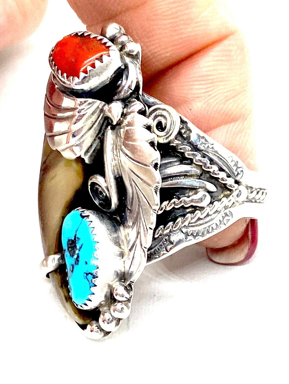 The handmade and intricately designed Ring features a large bear claw. 
The surrounding gemstones are turquoise and coral set in textured bezels.
Color of stones are rich and deep toned.
Bear claw is 1-1/2 inches long by 3/4 inch wide

Size:
1 3/4