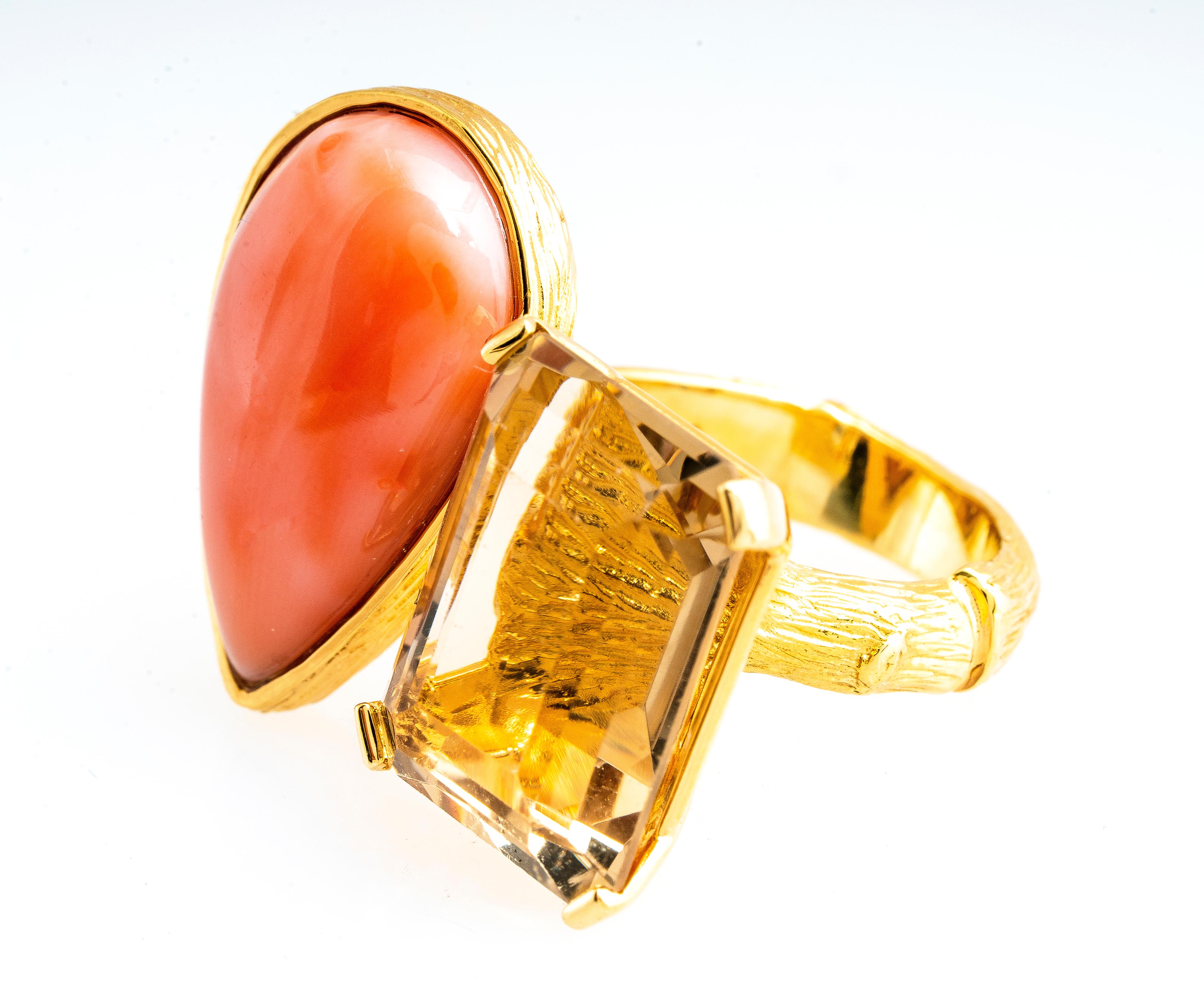 Vintage 18k yellow gold pink Coral and quartz twig ring by K. Brunini Jewels.  Pear shaped coral measures 22.5mm x 14mm.  The emerald shaped quartz measures 17.5mm x 13.4mm.  The ring shank is bamboo or twig shaped and the bezel around the coral has