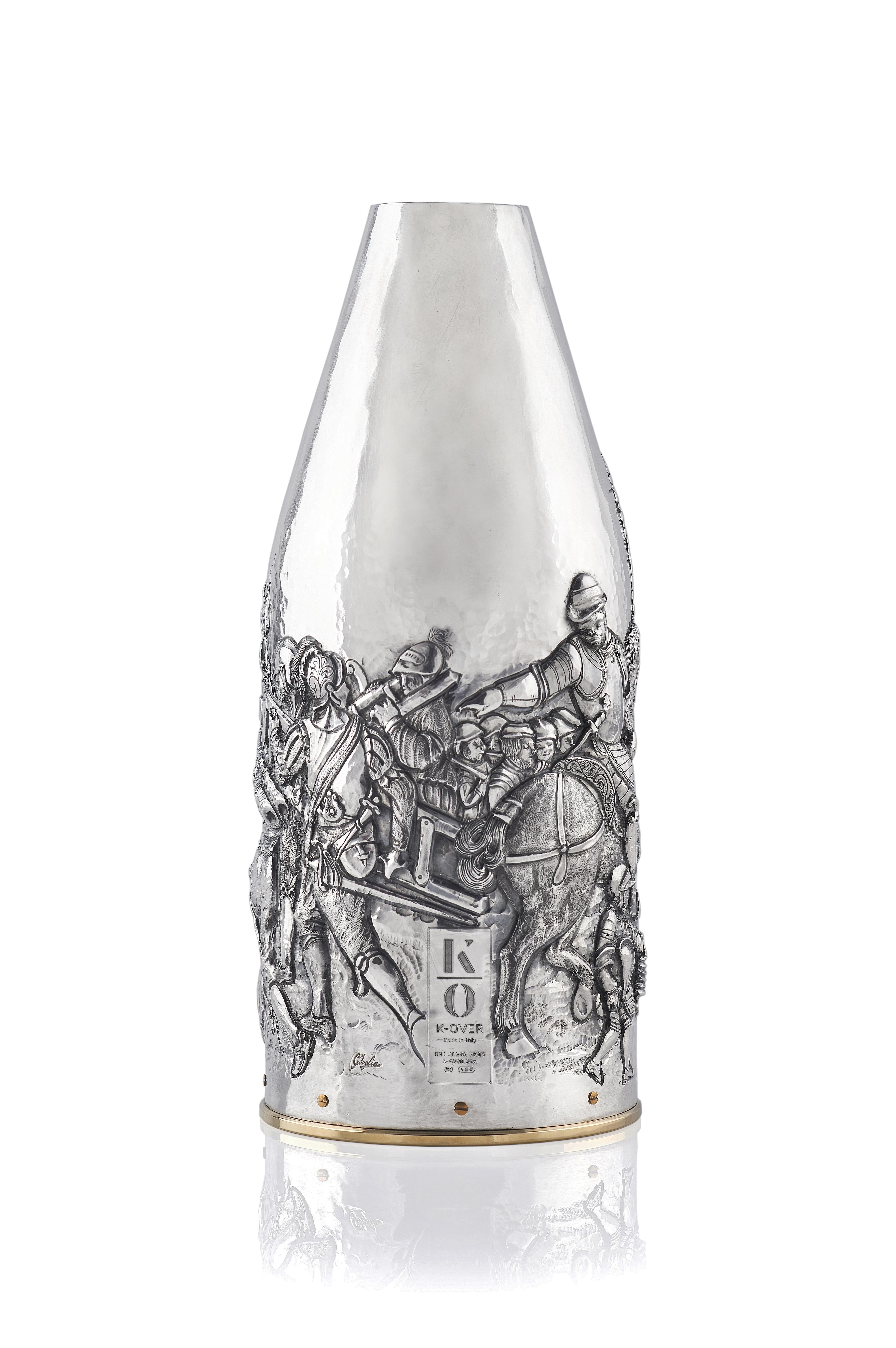 Questa cover per bottiglia di champagne è una vera opera d’arte. L’artista ha riprodotto, il famoso dipinto la “battaglia di porta Camollia” di Giorgio Vasari (in palazzo Vecchio a Firenze) su una K-OVER in argento puro 999/°°, cesellando cosa