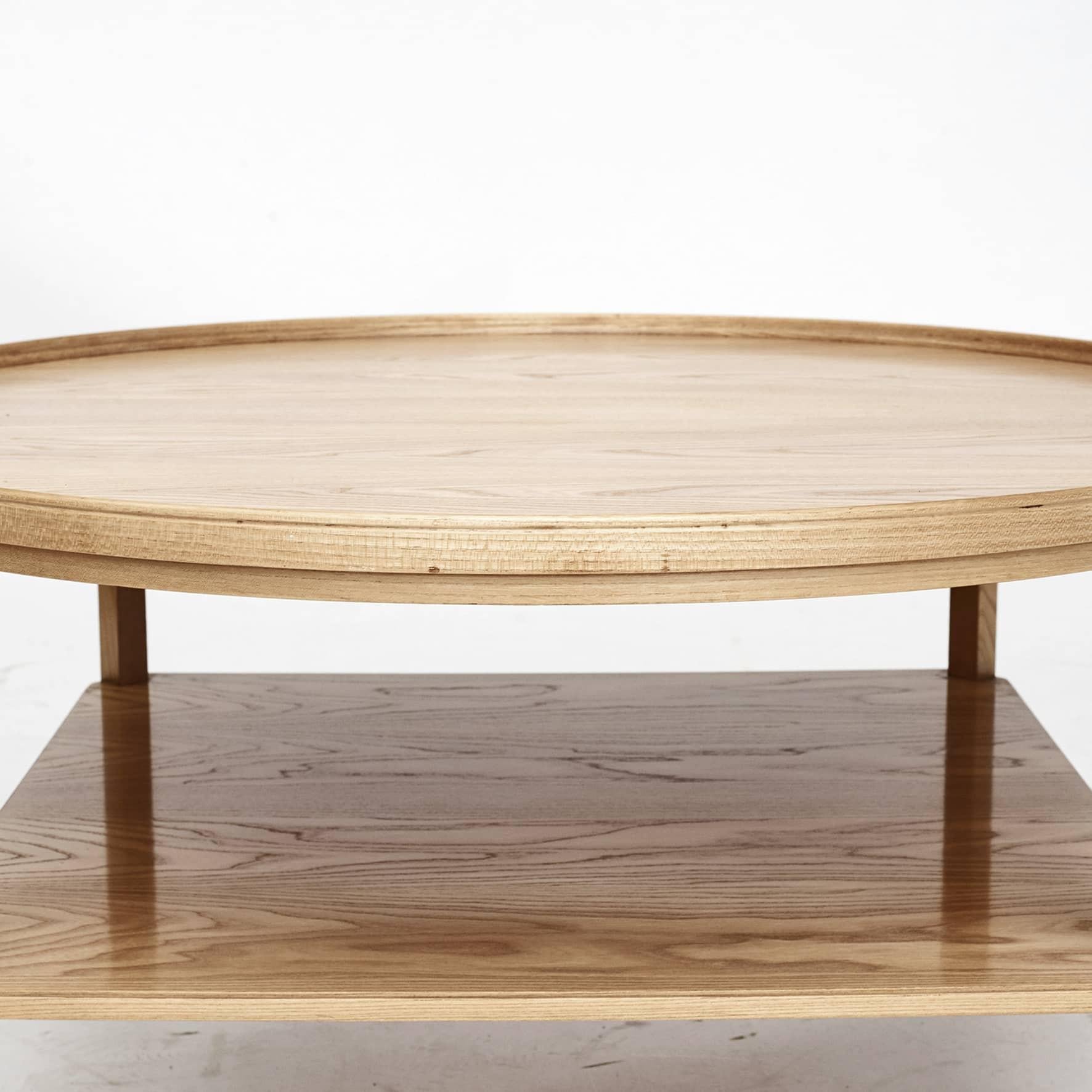 Kaare Klint 1888 - 1954.
Round coffee table made of elm wood.
Table top with a profiled edge.
Lower shelf with profiled edge and profiled leg between lower shelf and the top.
Designed in 1929 model 6687, called smoking table.

Great freshly