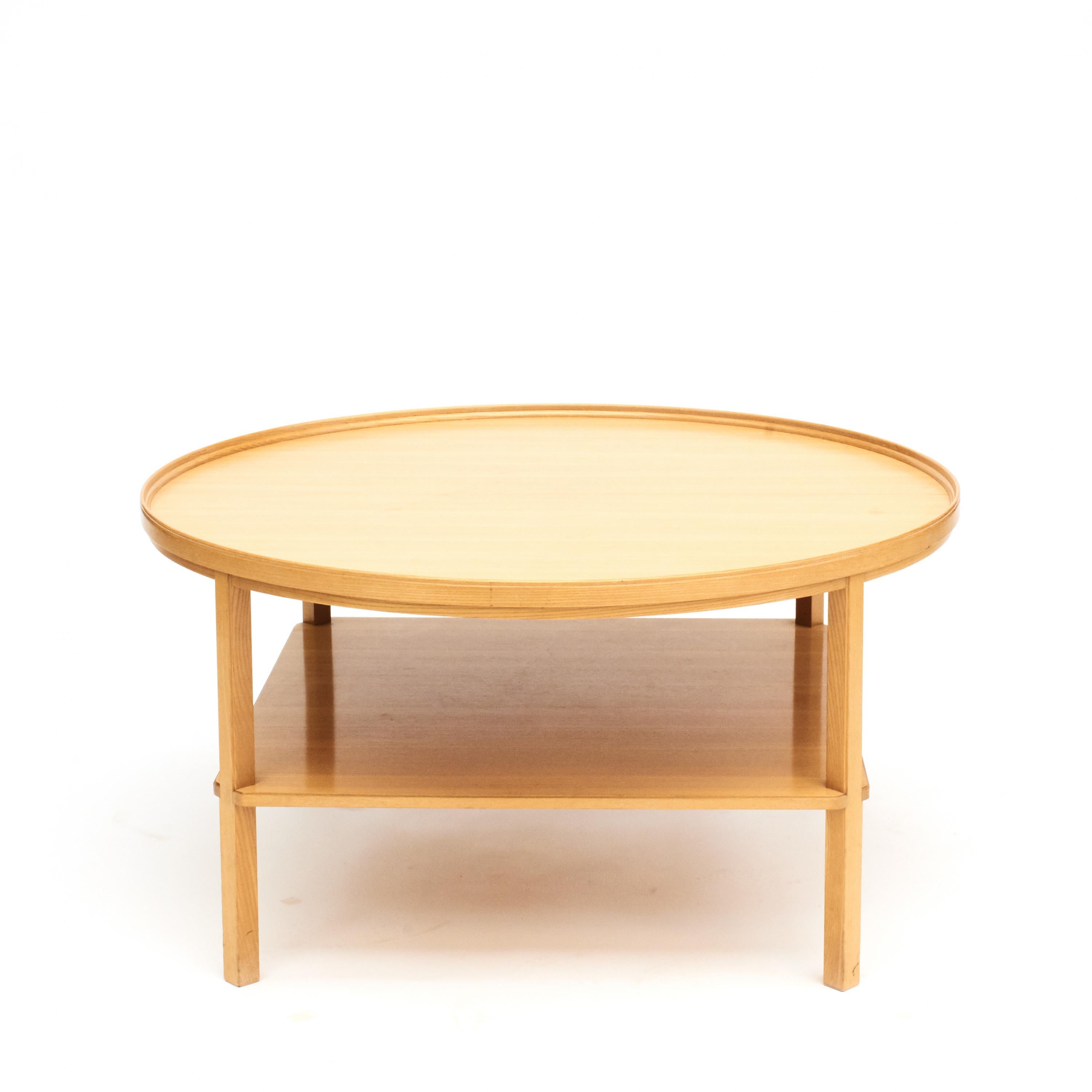 Round oak wood coffee table by Kaare Klint, model 6687.
Made in oak with lower shelf and a raised rim around the table top.
Designed in 1929 by Kaare Klint (1888-1954).
Produced by Rud. Rasmussen approx. 1950. Under tabletop manufacturer's label.
