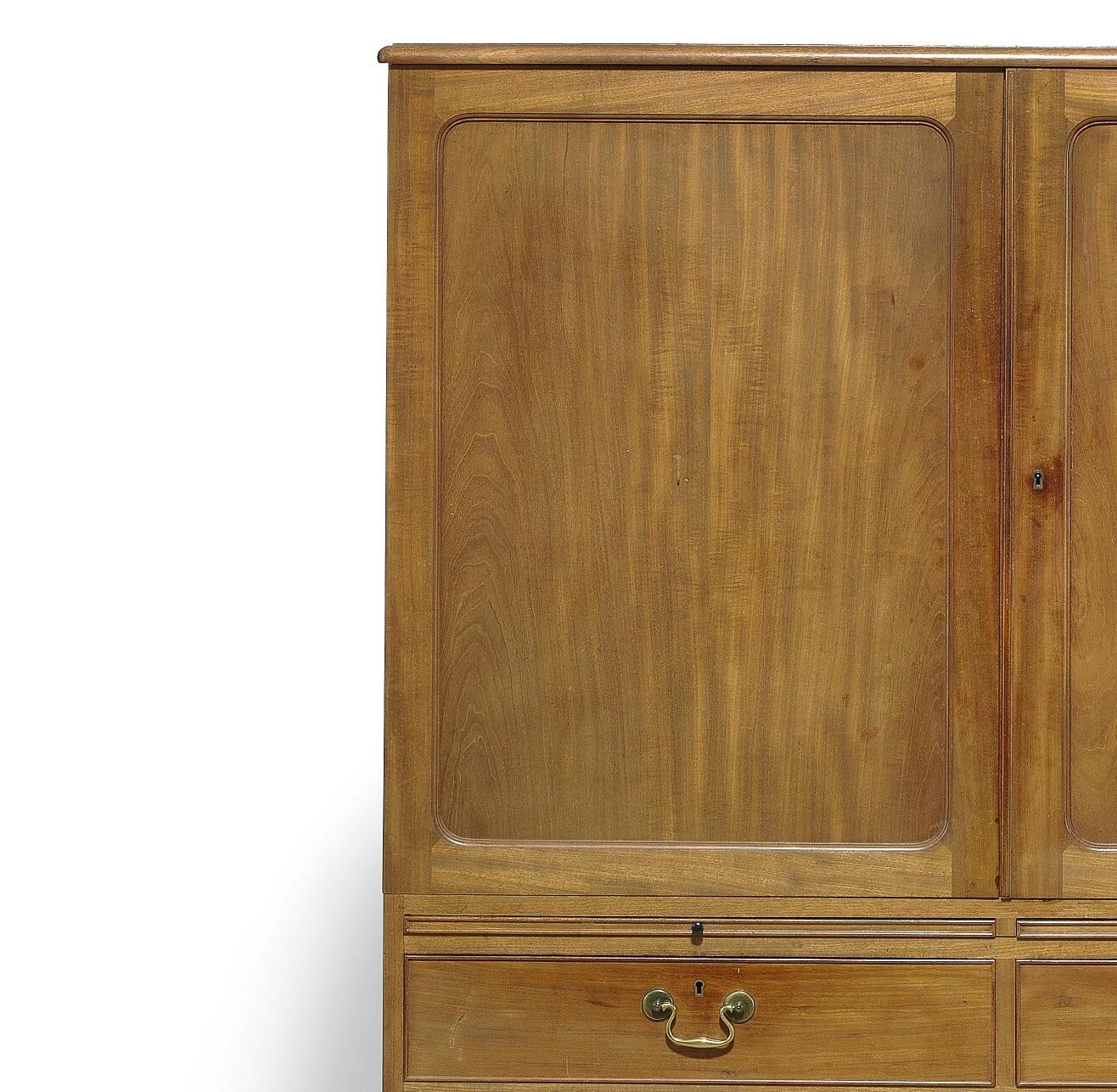 Cabinet of Cuban mahogany. Front with two doors and two pull-out leaves with handles of black ebony, interior with trays. Two smaller and one large drawer with brass handles, brass fittings. Model 4268. Designed 1931. This example made 1930s by Rud.