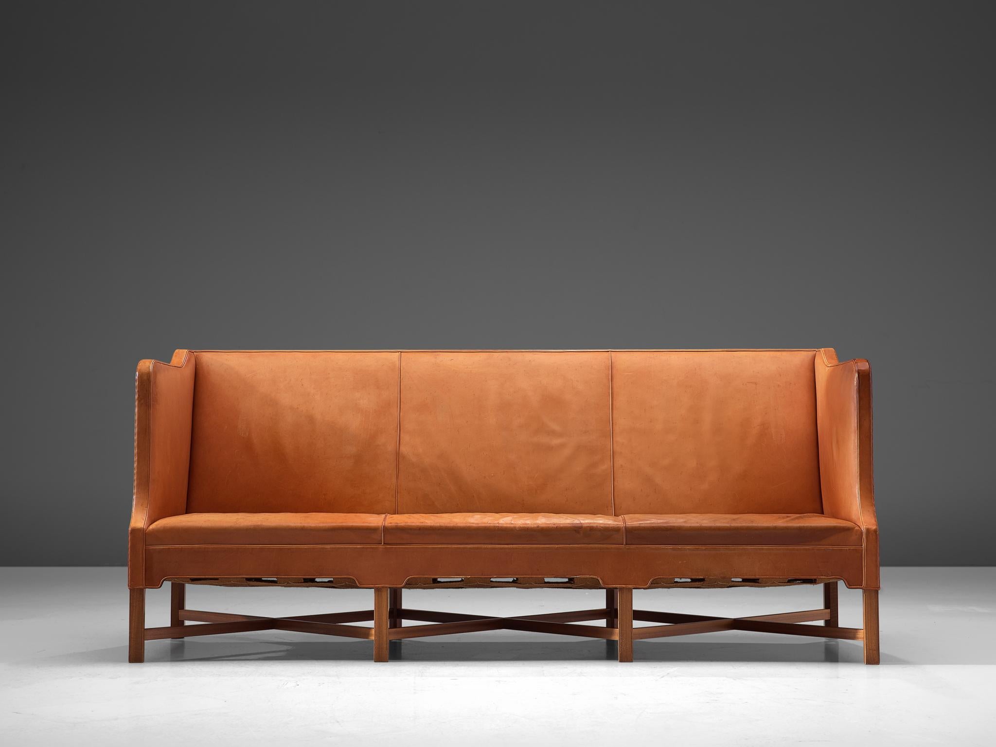 Kaare Klint for Rud Rasmussen, sofa model 4118, in leather and mahogany, by Denmark, 1929, made in 1950s.

Classic and elegant Scandinavian three-seat sofa by Kaare Klint. This model was designed in 1929. The base consist of eight legs in mahogany