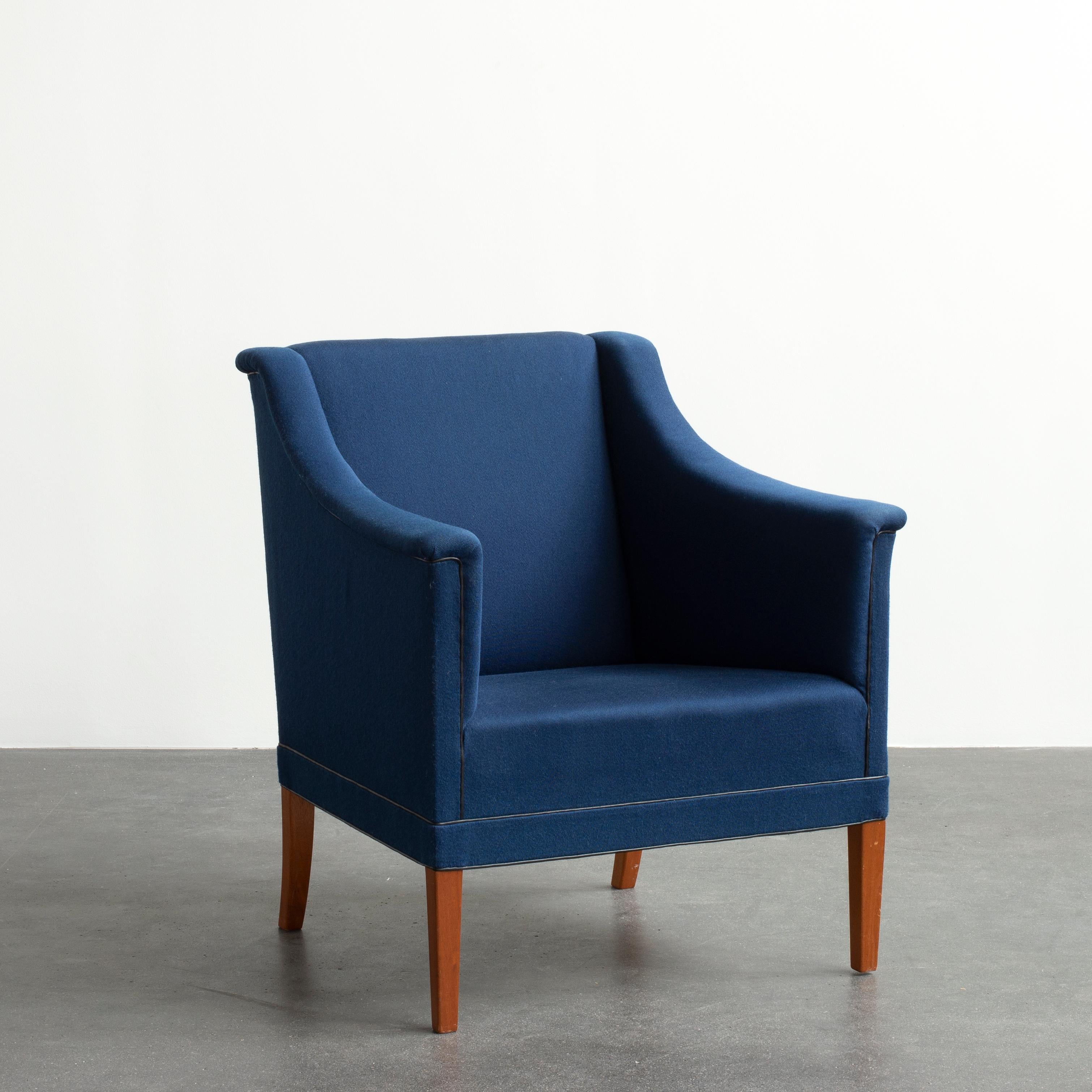 Kaare Klint easy chair with legs of mahogany. Seat, sides and back upholstered with blue wool. Executed by Rud. Rasmussen.

Reverse with paper label ‘RUD. RASMUSSENS/SNEDKERIER/KØBENHAVN/DANMARK and architect's monogrammed paper label.
