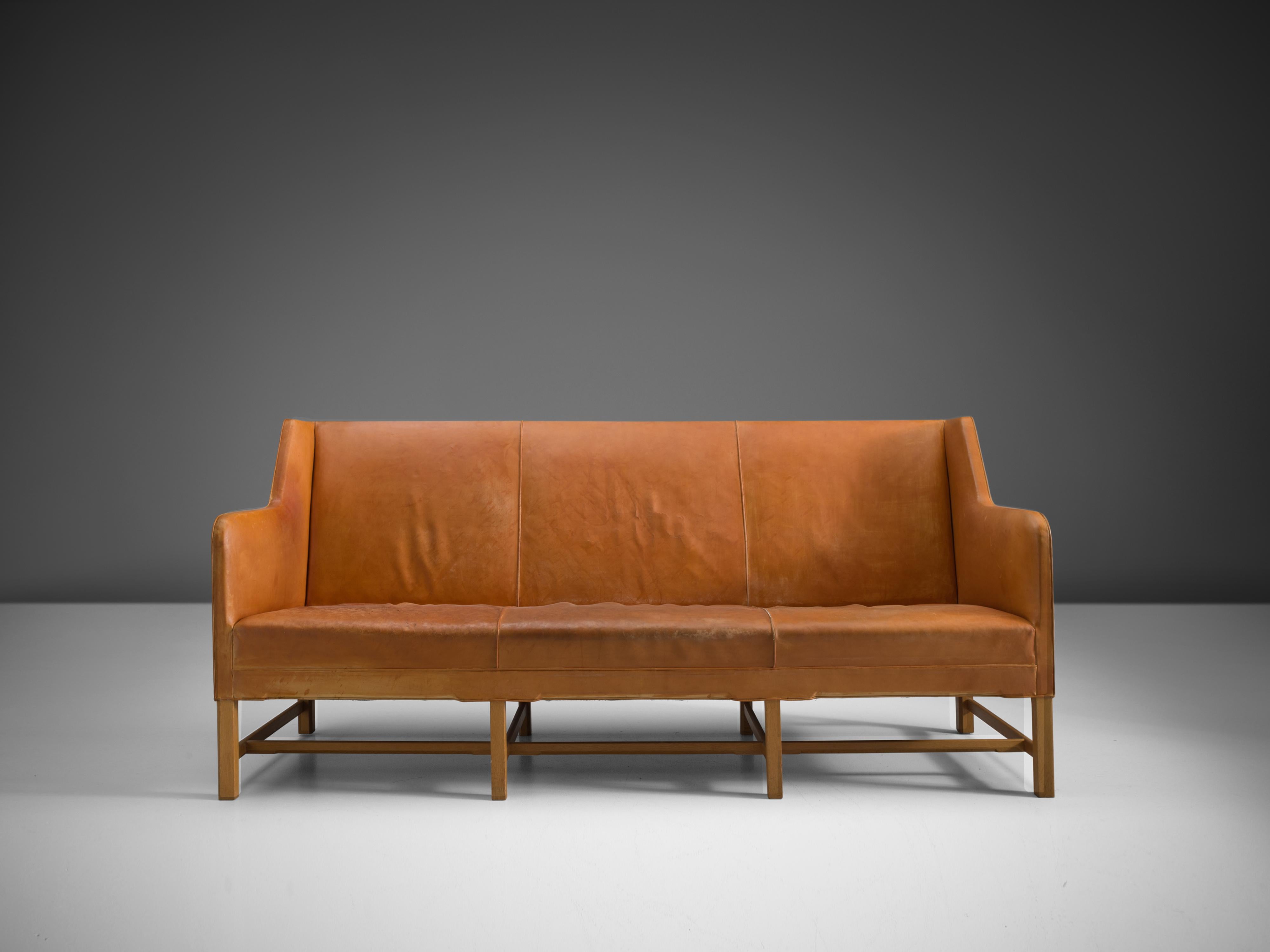Kaare Klint for Rud Rasmussen, sofa model 4118, leather, wood, Denmark, design 1929

Classic and elegant Scandinavian three-seat sofa by Kaare Klint designed in 1935. The high back is structured by vertical lines into three parts that flow over into