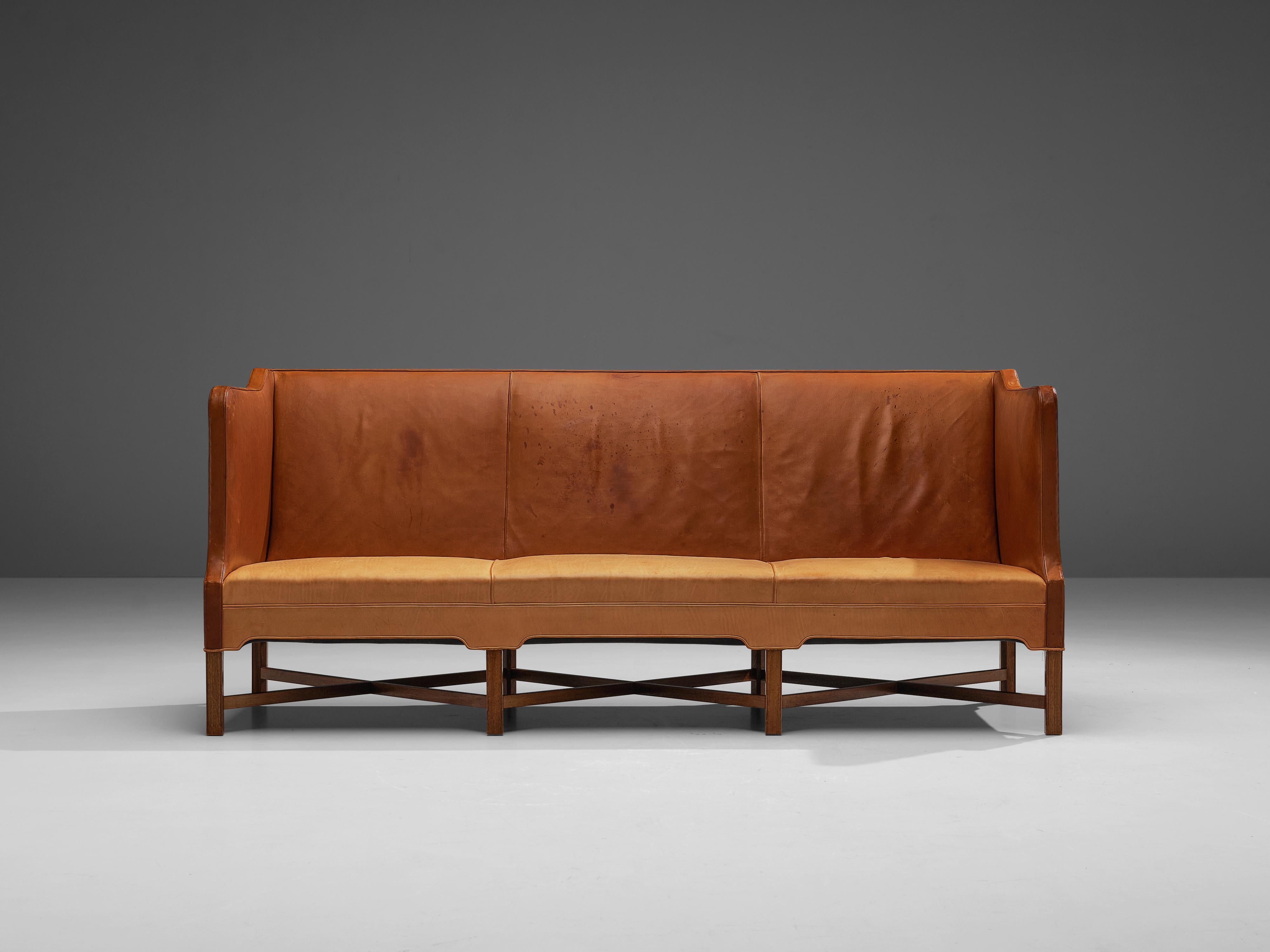 Kaare Klint for Rud Rasmussen, leather, mahogany, Denmark, design 1929

Classic and elegant Scandinavian three-seat sofa by Kaare Klint designed in 1929. The base consists of eight legs in mahogany with X-shaped cross-connections, which create a