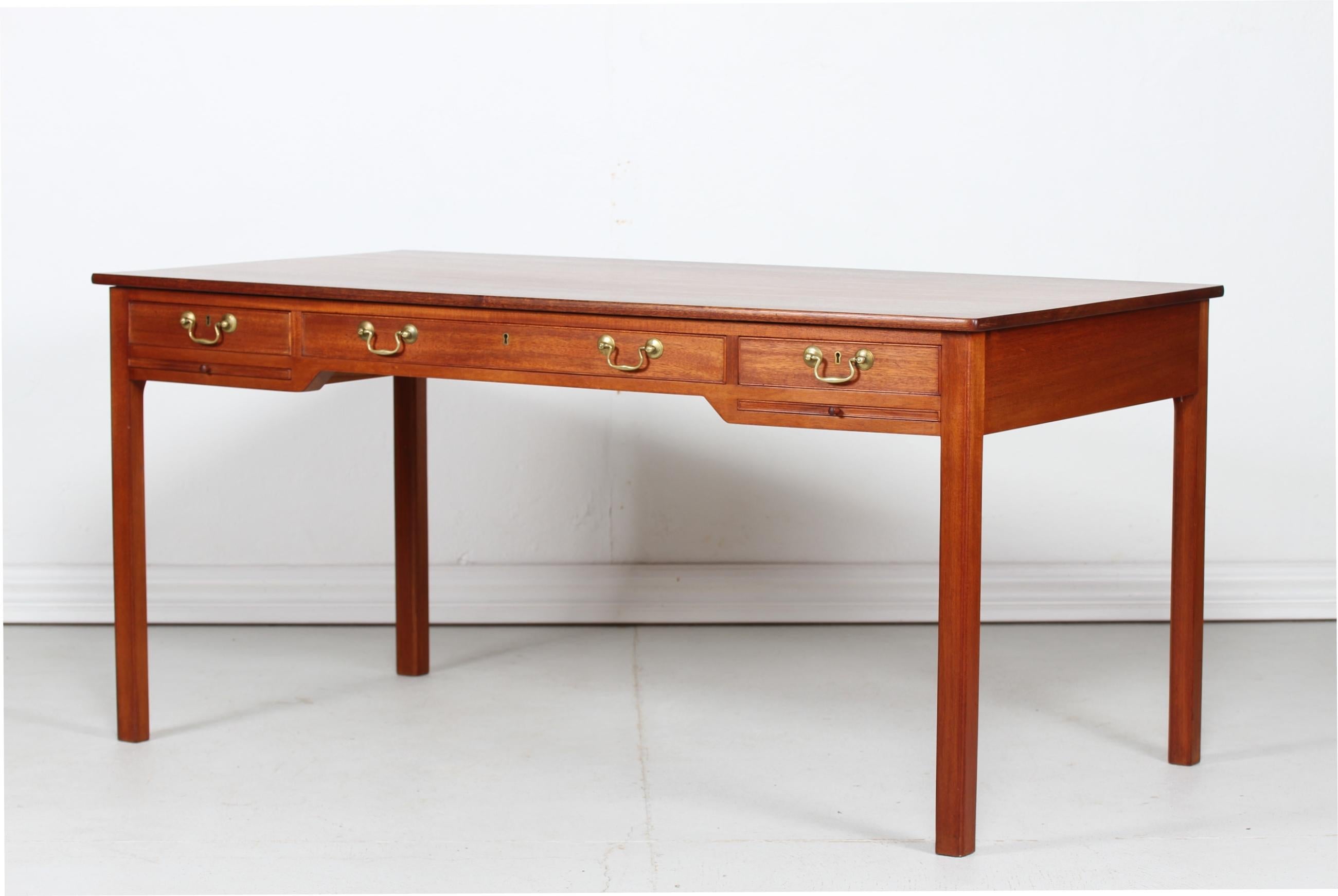 Large writing desk with drawers by the Danish architect and furniture designer Kaare Klint (1888-1954) Manufactured by Rud Rasmussen in Copenhagen
The desk is made of solid mahogany and mahogany veneer with oil treatment. 
The drawer handles are