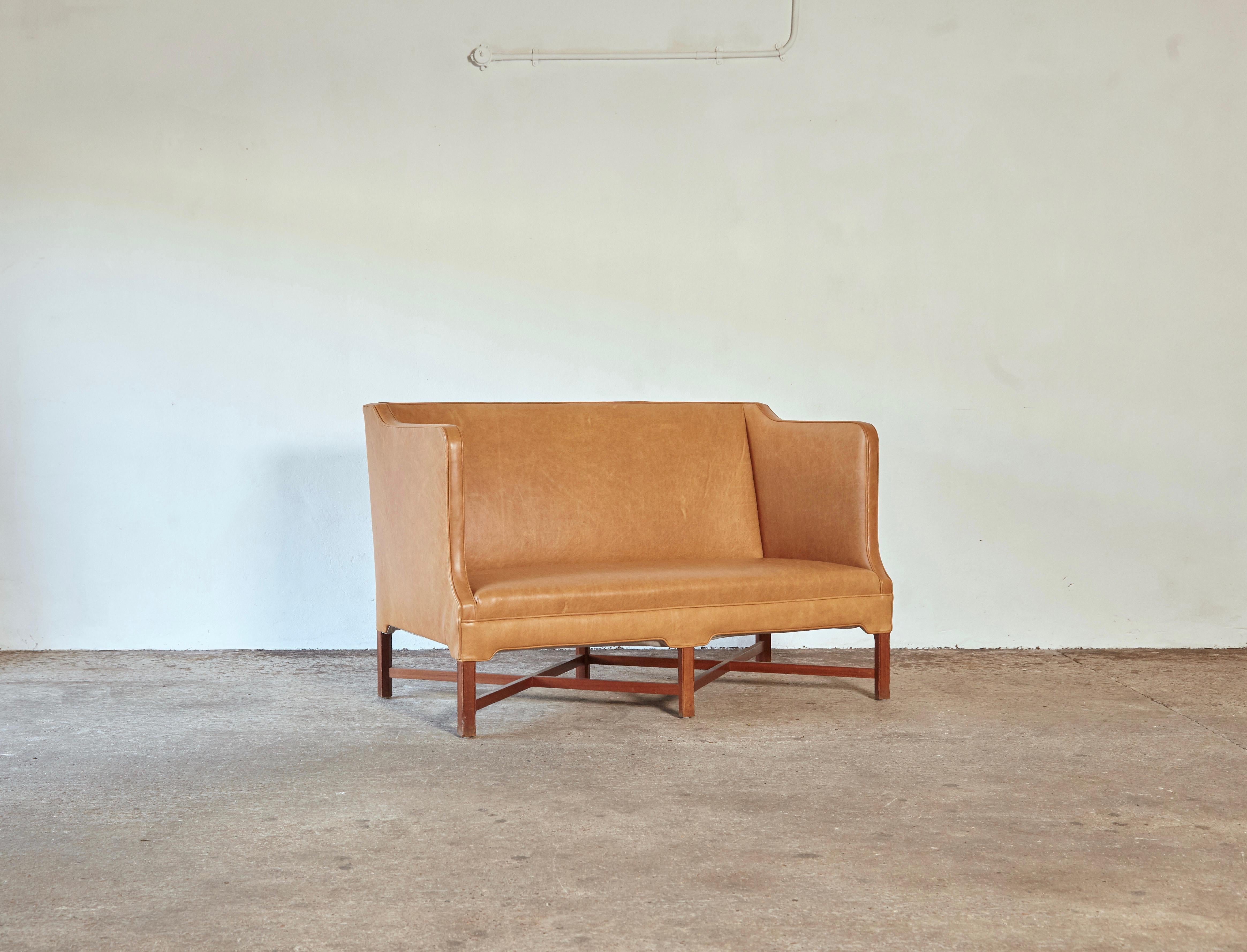 Rare Kaare Klint Model 4118 two-seat box sofa with profiled cross legged mahogany frame. Made by Rud Rasmussen, Copenhagen, Denmark. Upholstered in cognac leather.

Measures: H 87 cm, W 135 cm, D 70 cm.