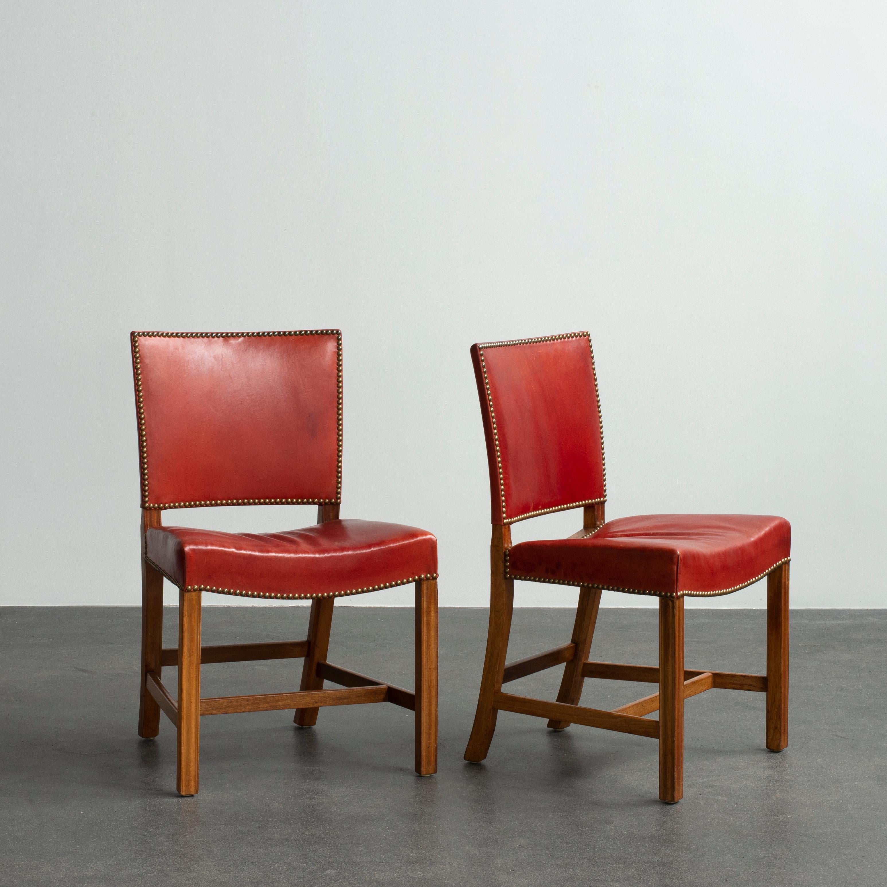 Kaare Klint pair of red chairs, mahogany, leather and brass. Executed by Rud. Rasmussen.

Underside with manufacturer's paper label RUD. RASMUSSENS/SNEDKERIER/45 NØRREBROGAD/KØBENHAVN, penciled number and architect's monogrammed paper label.