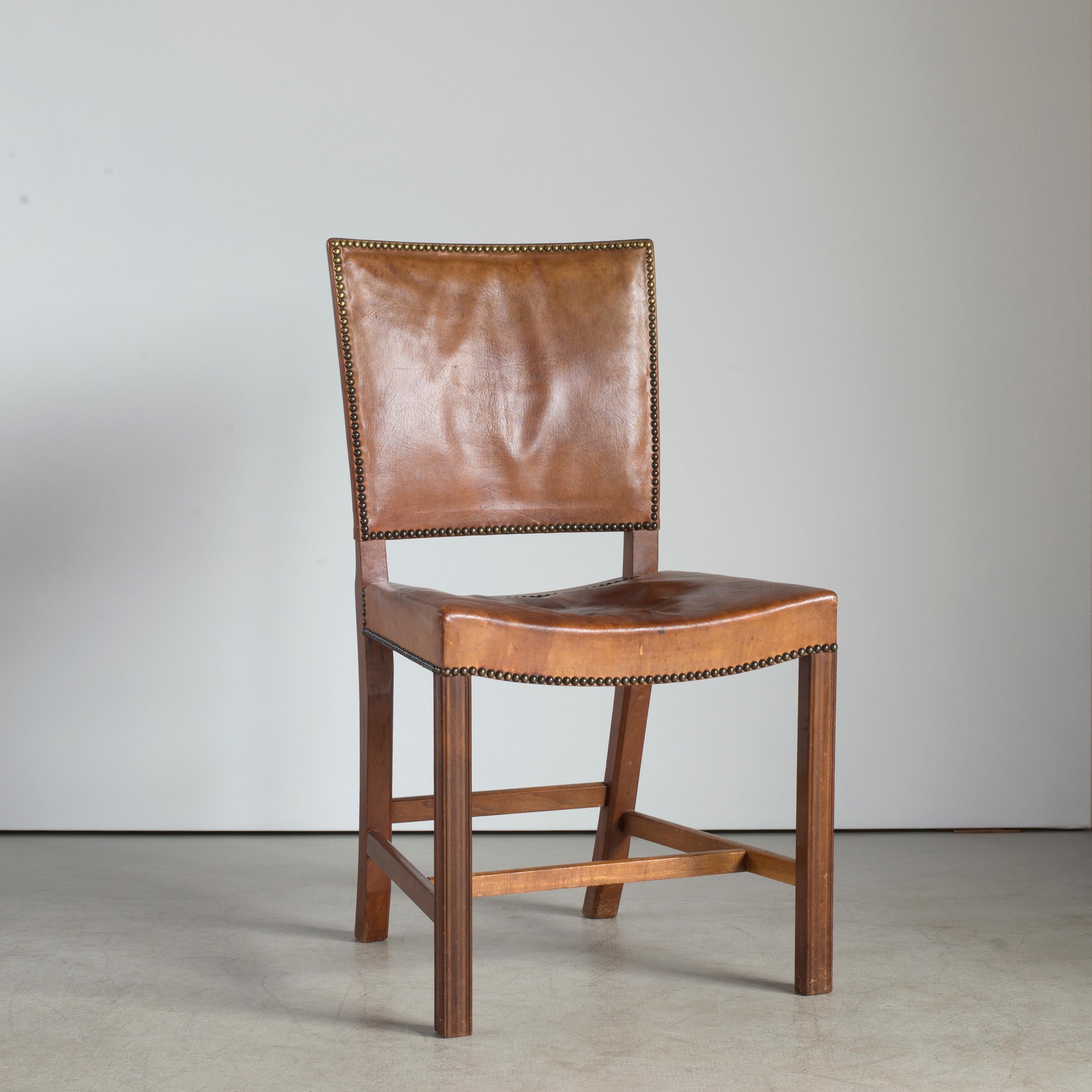 Kaare Klint red chair. Executed by Rud. Rasmussen.

Mahogany, Niger leather and brass nails. 

Underside with manufacturer's paper label RUD. RASMUSSENS/SNEDKERIER/45 NØRREBROGAD/KØBENHAVN, pencilled number and architect's monogrammed paper label.