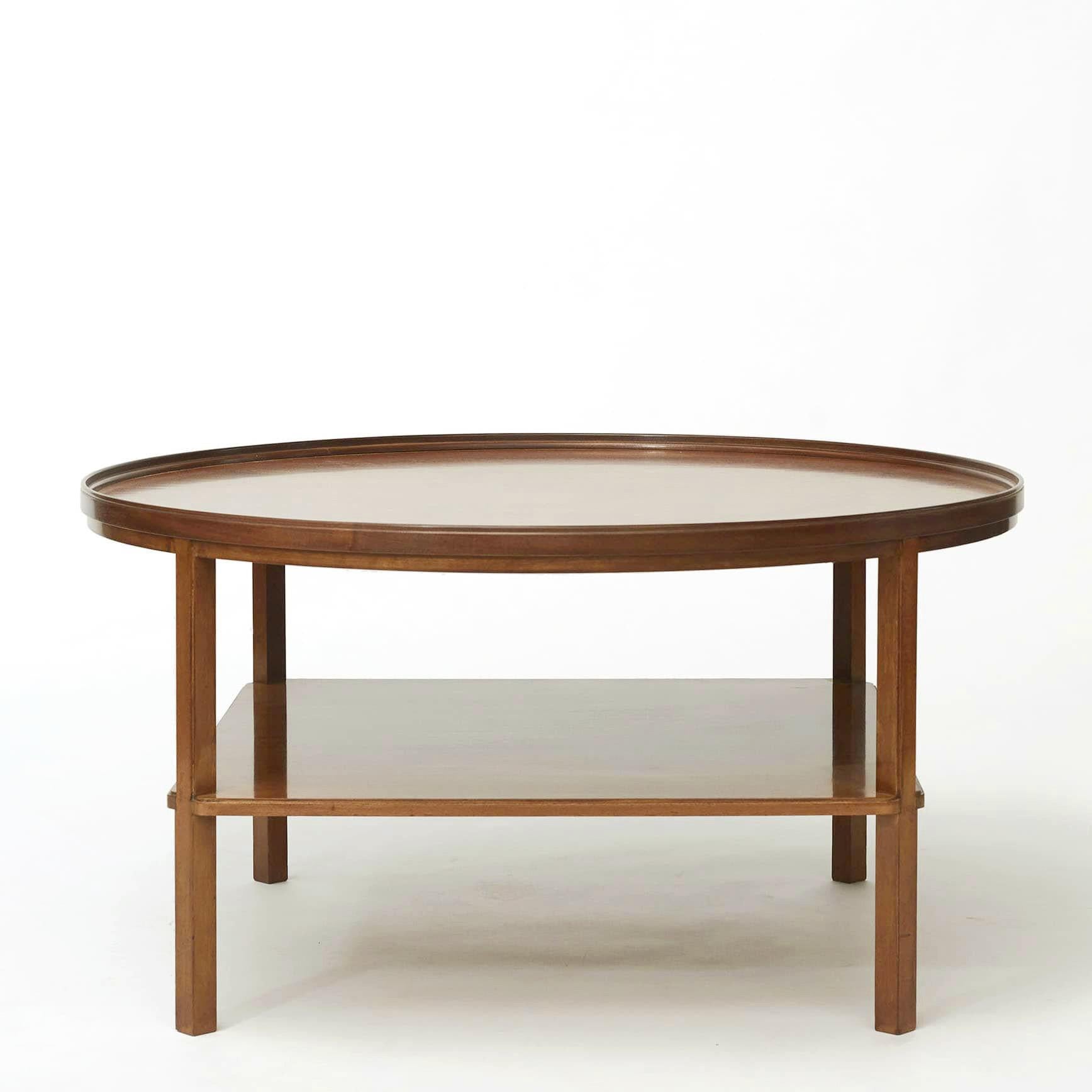 Kaare Klint 1888-1954.
Round mahogany coffee table, table top with profiled kehlet edge. Base shelf with profiled edge and profiled legs between table top and base shelf. Legs from lower shelf and down, without profile.

Designed in 1929, model