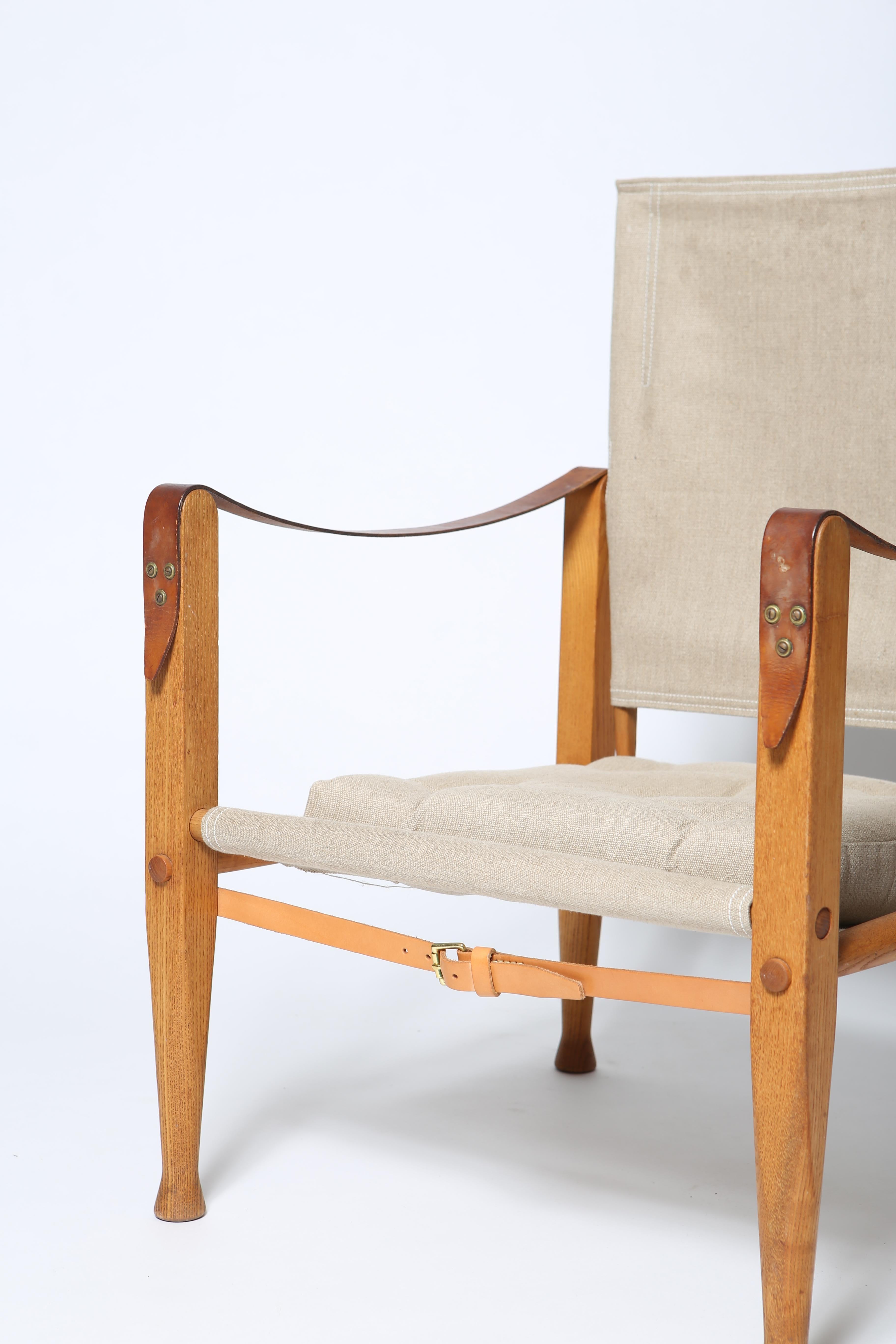 Chaise safari originale et iconique du professeur Kaare Klint. Conçu en 1927. Cette version date des années 1960 et est réalisée en frêne massif. Belle patine du bois, non restauré. Les éléments en toile sont plus récents et fabriqués exactement