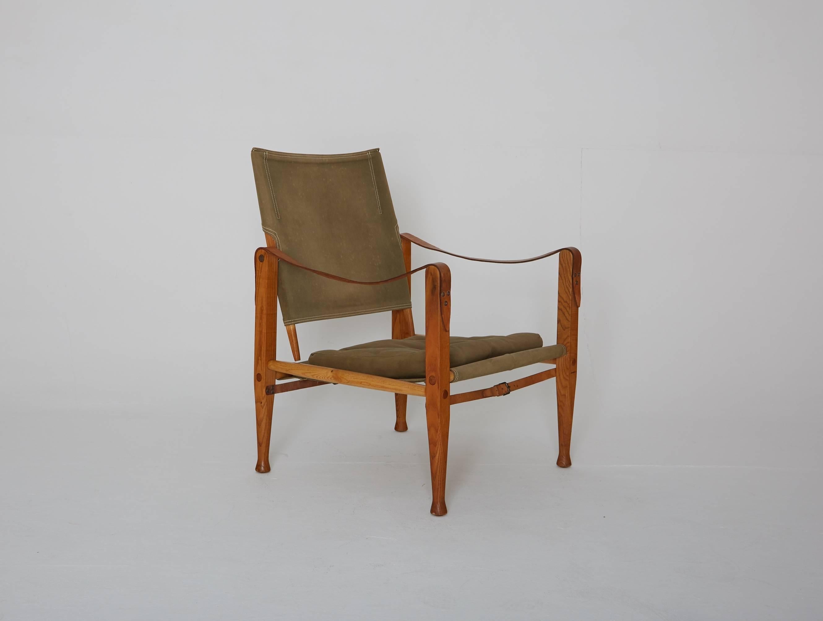 A Kaare Klint safari chair, made by Rud Rasmussen, Denmark, 1960s. Original faded khaki canvas and ashwood. Some water marks and spots to canvas.