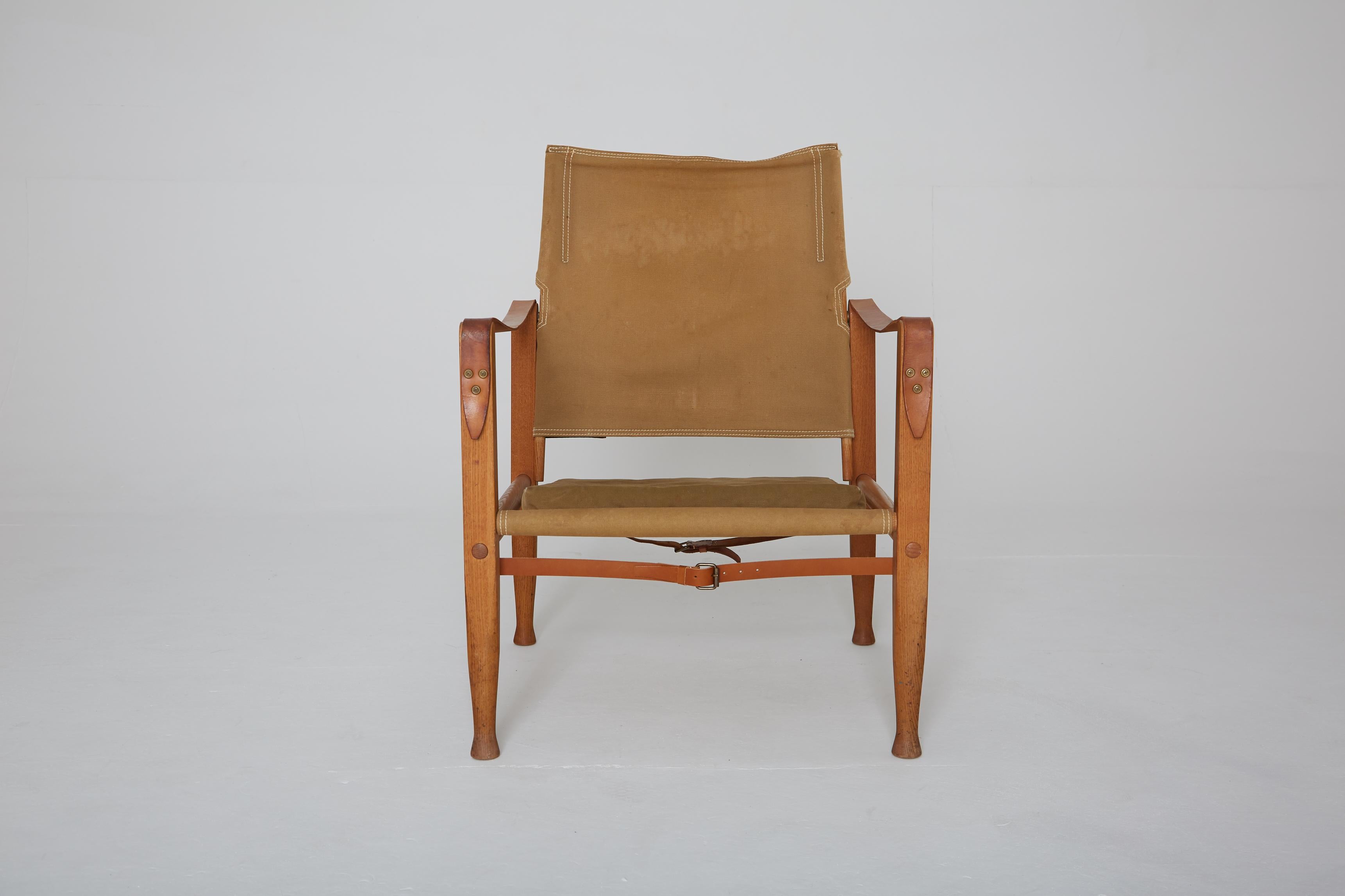 A Kaare Klint safari chair, made by Rud Rasmussen, Denmark, 1960s. Original faded khaki canvas and ashwood. Some marks and spots and some signs or use and wear.
 
   