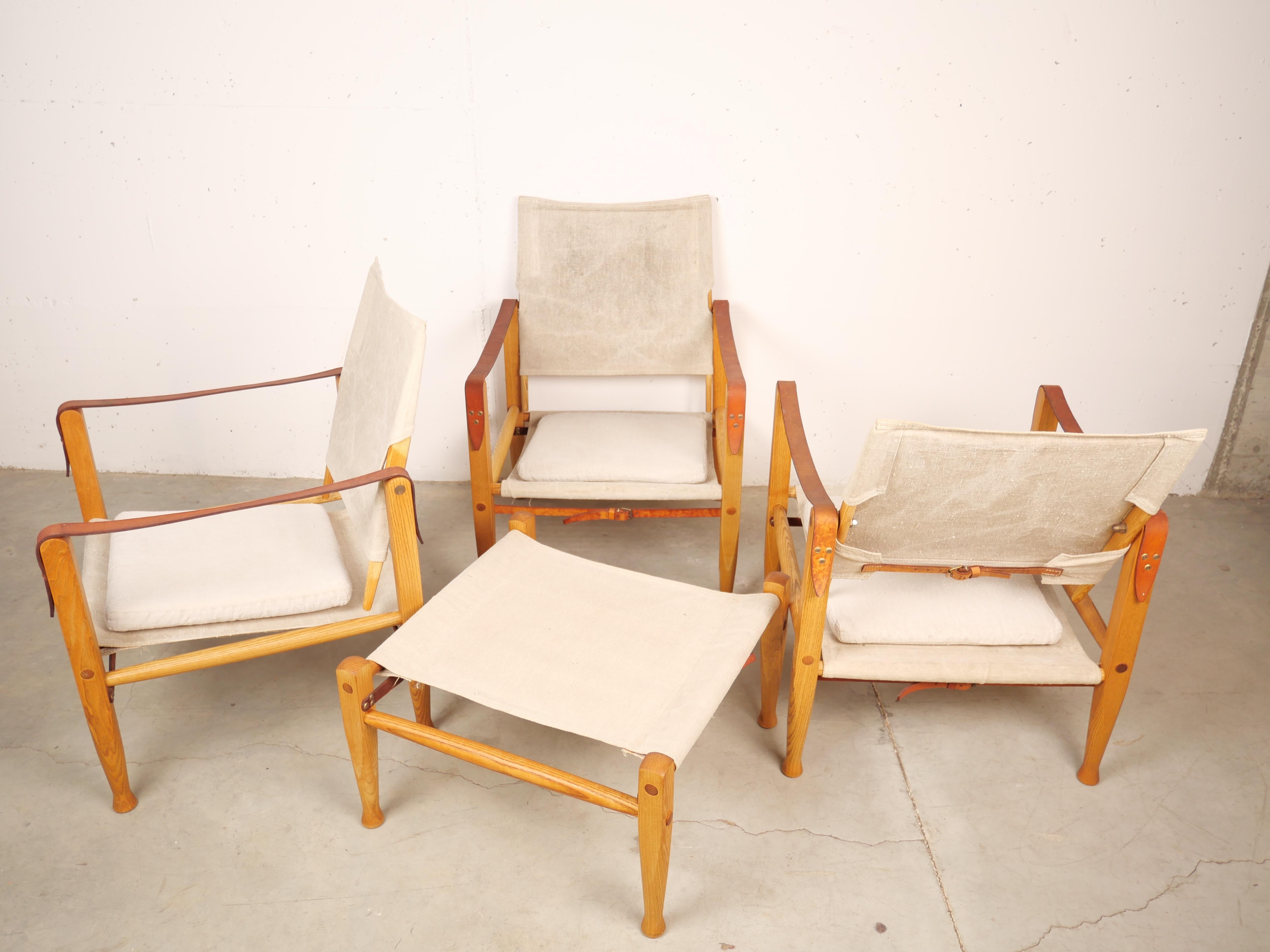 3 vintage iconic Safari chairs and a footstool with their oridinal fabric designed by Kaare Klint for Rud Rasmussen furniture makers. Kaare Klint designed the safari chairs in 1933. These iconic chairs are made of ash, canvas and leather. Kaare