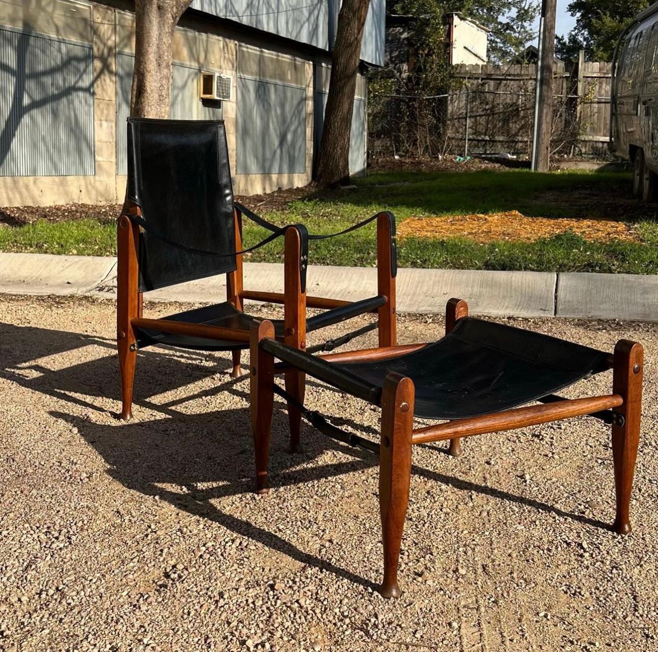 Chaise Safari iconique en cuir noir de Kaare Klint avec ottoman/pouf assorti. Le fauteuil s'incline bien et supporte le poids. Les courroies en cuir d'origine sont intactes et ne présentent qu'une patine minimale. 
