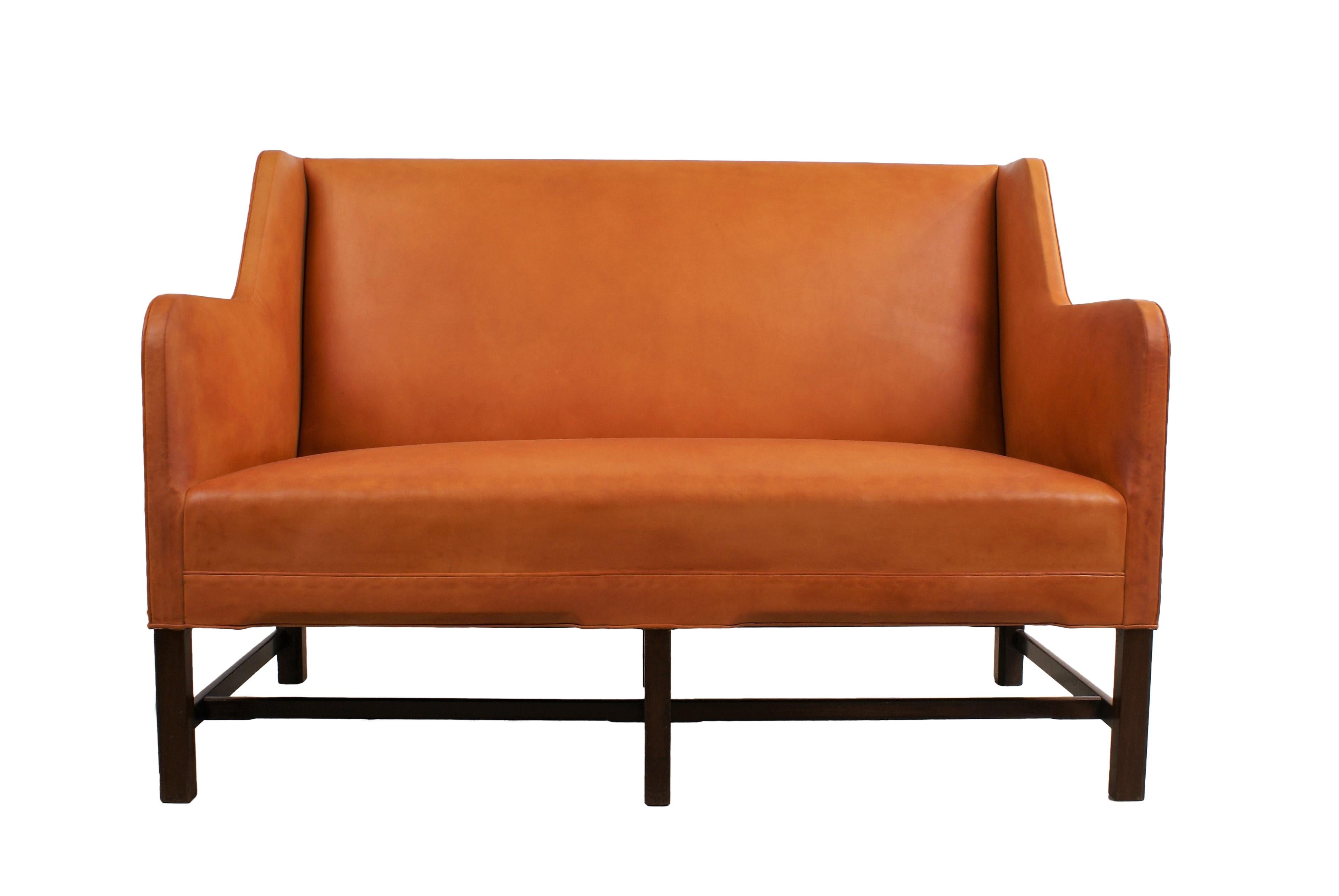 Kaare Klint, two-seat settee with six-legged Cuban mahogany frame. Sides, seat and back re-upholstered with natural leather. Model 5011. Made by Rud. Rasmussen Cabinetmakers, Copenhagen, Denmark.

Literature: Gorm Harkaer, Klintiana: “Kaare