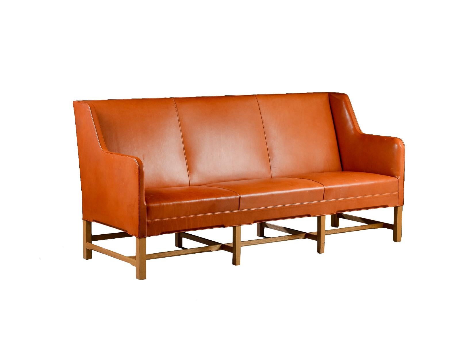 Three-seater sofa model 5011 in original leather and eight-legged ash base. Produced by Rud. Rasmussen Cabinetmakers, Denmark. Minor marks on the frame, patina to the leather.
Shown at the Copenhagen Cabinetmakers’ Guild exhibition in