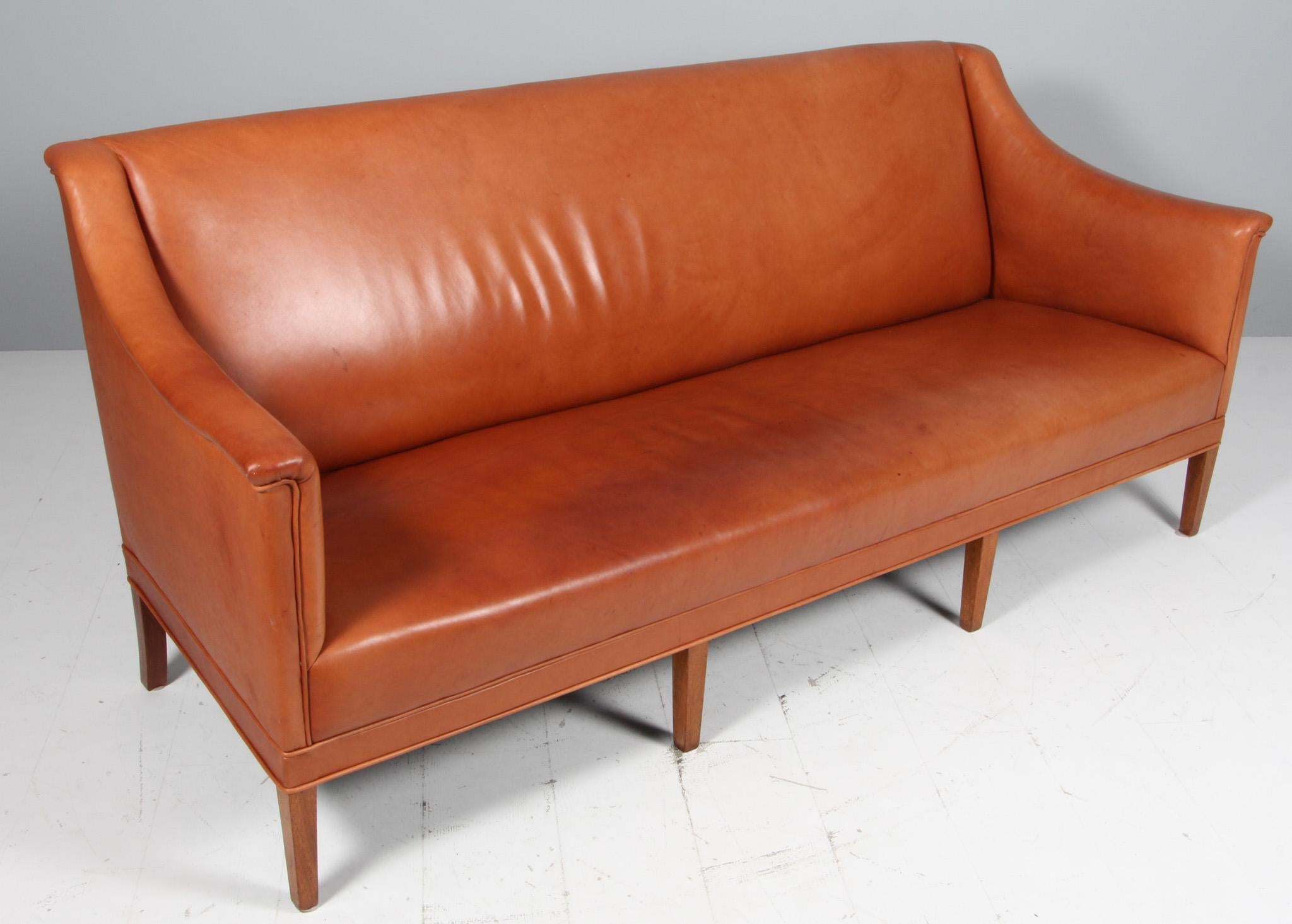Kaare Klint sofa in patinated tan leather.

Legs of mahogany.

Made by Rud Rasmussen, model 6092.