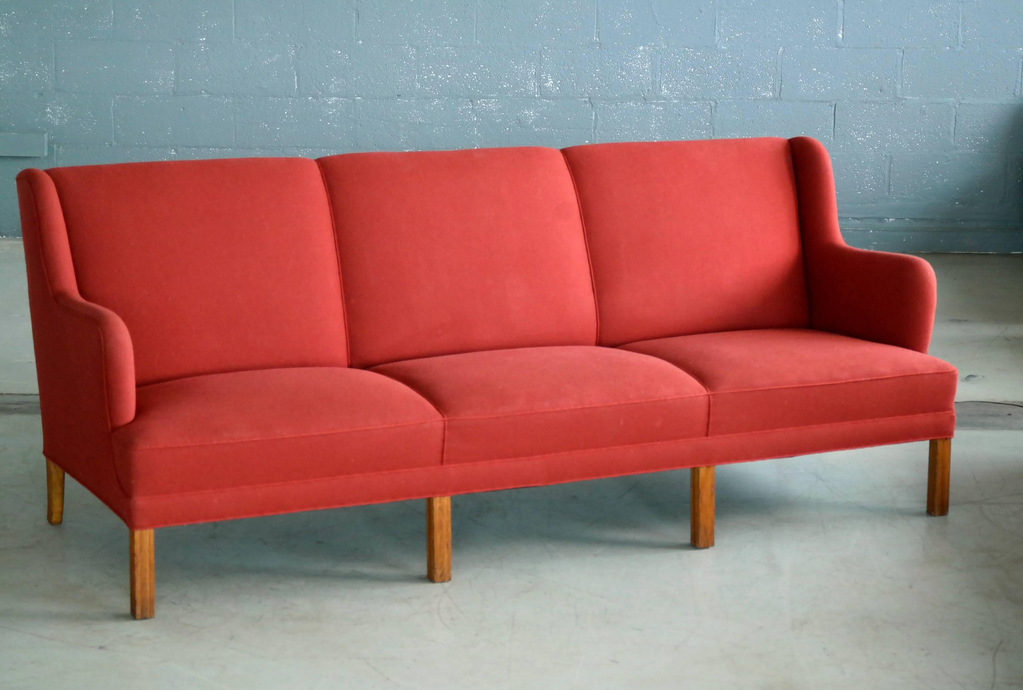 This very elegant and generously sized three-seat sofa was designed and made by the Danish Master Cabinetmaker, Frits Henningsen, circa 1950. Henningsen was a Master Carpenter and Furniture maker and his furniture is increasingly sought after. This