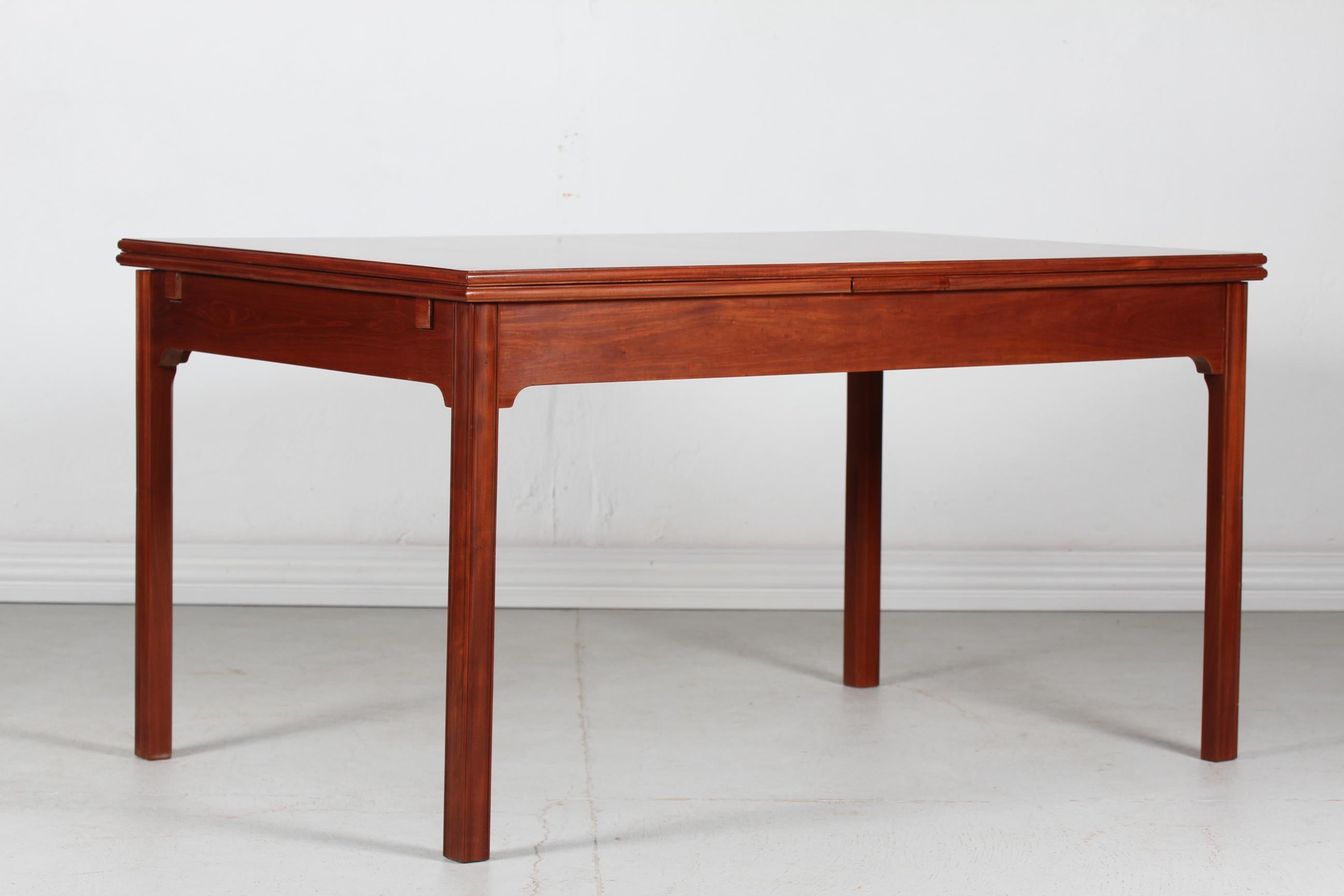 Vintage dining table model no. 4229 by the Danish architect and furniture designer Kaare Klint (1888-1954) 
Manufactured by Rud Rasmussen in the 1950s in Copenhagen.
The classic table is made of mahogany with lacquer, Two pull-out-leaves make