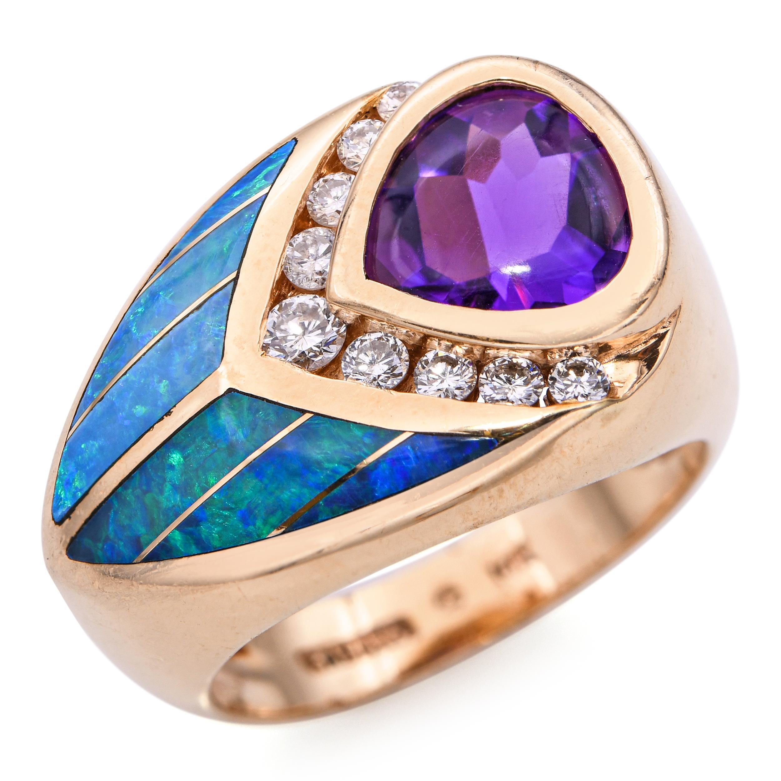 Questo anello sorprendente presenta un design audace con una vibrante ametista viola come centro. La gemma è elegantemente circondata da una fila di diamanti scintillanti che ne esaltano la brillantezza. Il cinturino presenta sezioni di opale blu