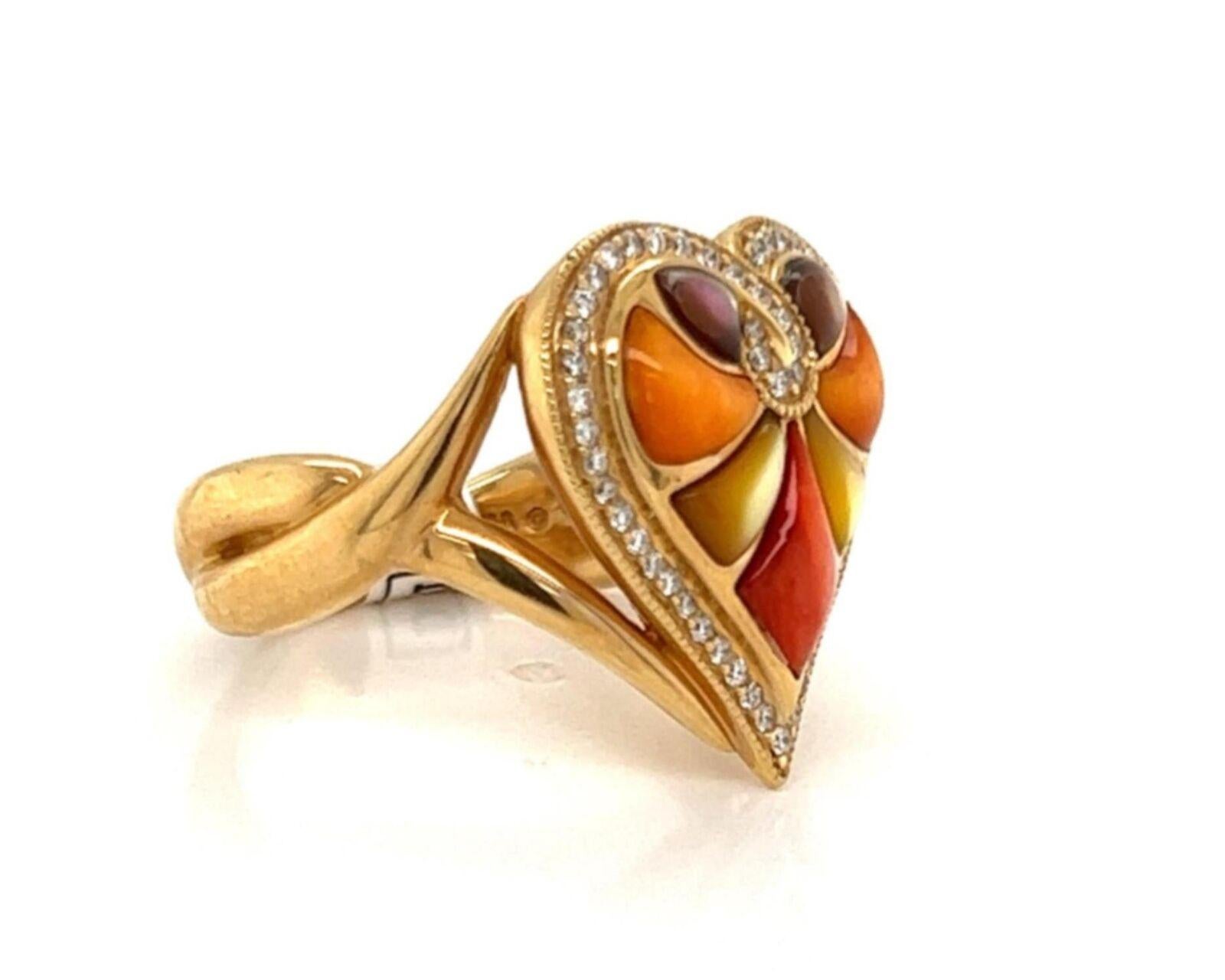 This lovely authentic ring is by Kabana, crafted from 14k yellow gold featuring a split shank with double band in a crossover woven style around the back of the band.  The front of the ring has a stunning heart shape frame with red and orange spiny