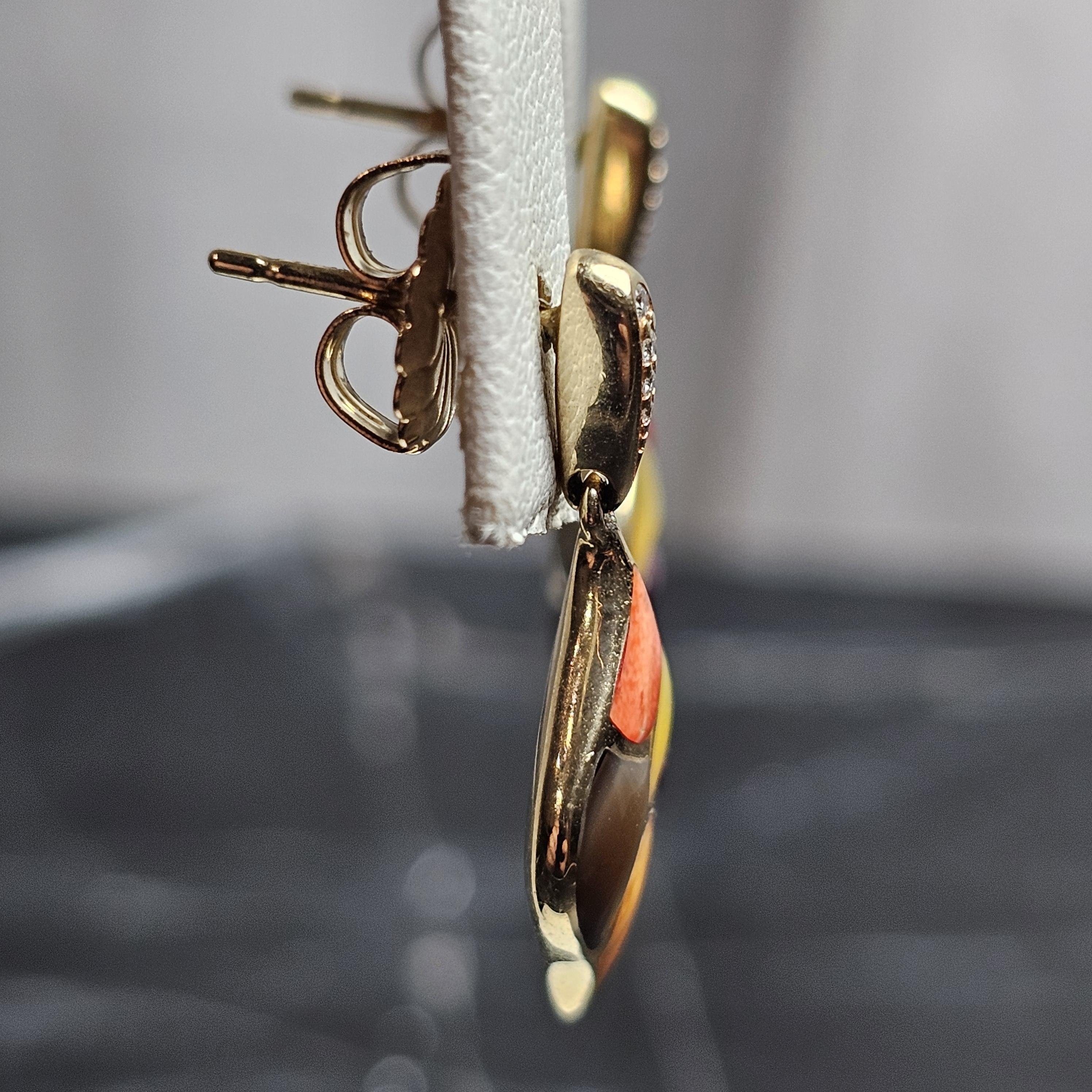 Nous avons ici une paire de boucles d'oreilles pendantes en or jaune 14k Kabana.
Cette paire présente une incrustation vibrante de plusieurs couleurs d'huîtres épineuses, de nacre et de petits diamants. 

**Spécifiques**
- Dimensions : 1,0
