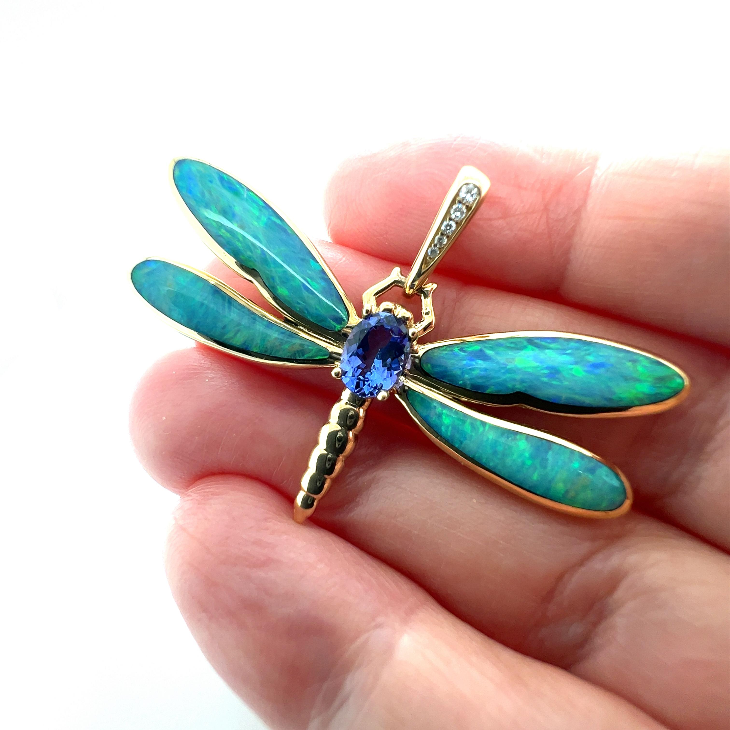 Questo raffinato ciondolo Kabana cattura l'essenza dell'eleganza con il suo intricato design a libellula, realizzato in lucente oro giallo 14k. Il ciondolo è ornato da un'ipnotica serie di opali naturali, tanzanite e diamanti che donano un vibrante