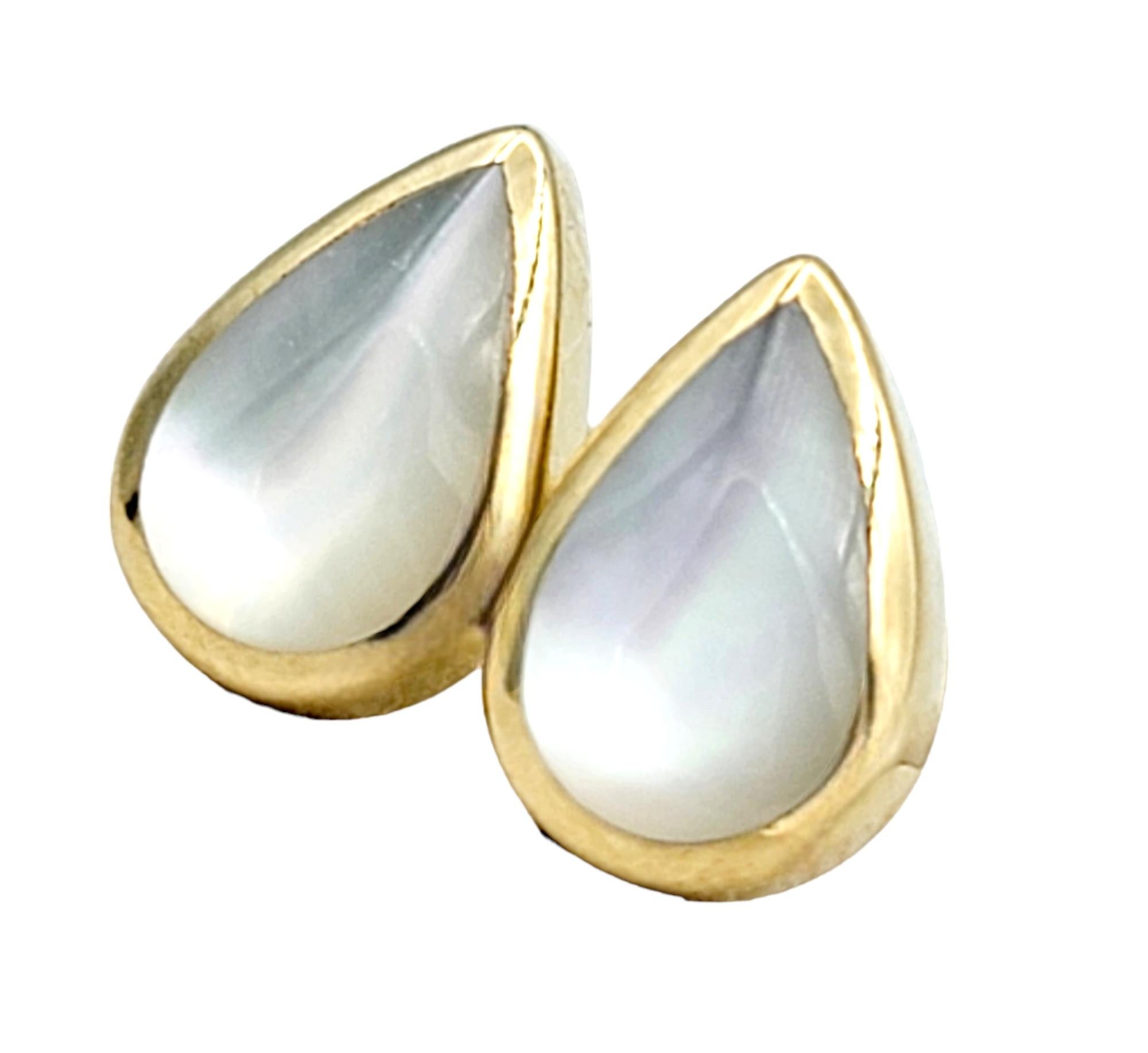 These exquisite petite Kabana stud earrings embody timeless elegance and artisan craftsmanship. Each earring features a delicate teardrop-shaped frame meticulously crafted from lustrous 14 karat yellow gold. The warm hue of the gold complements the