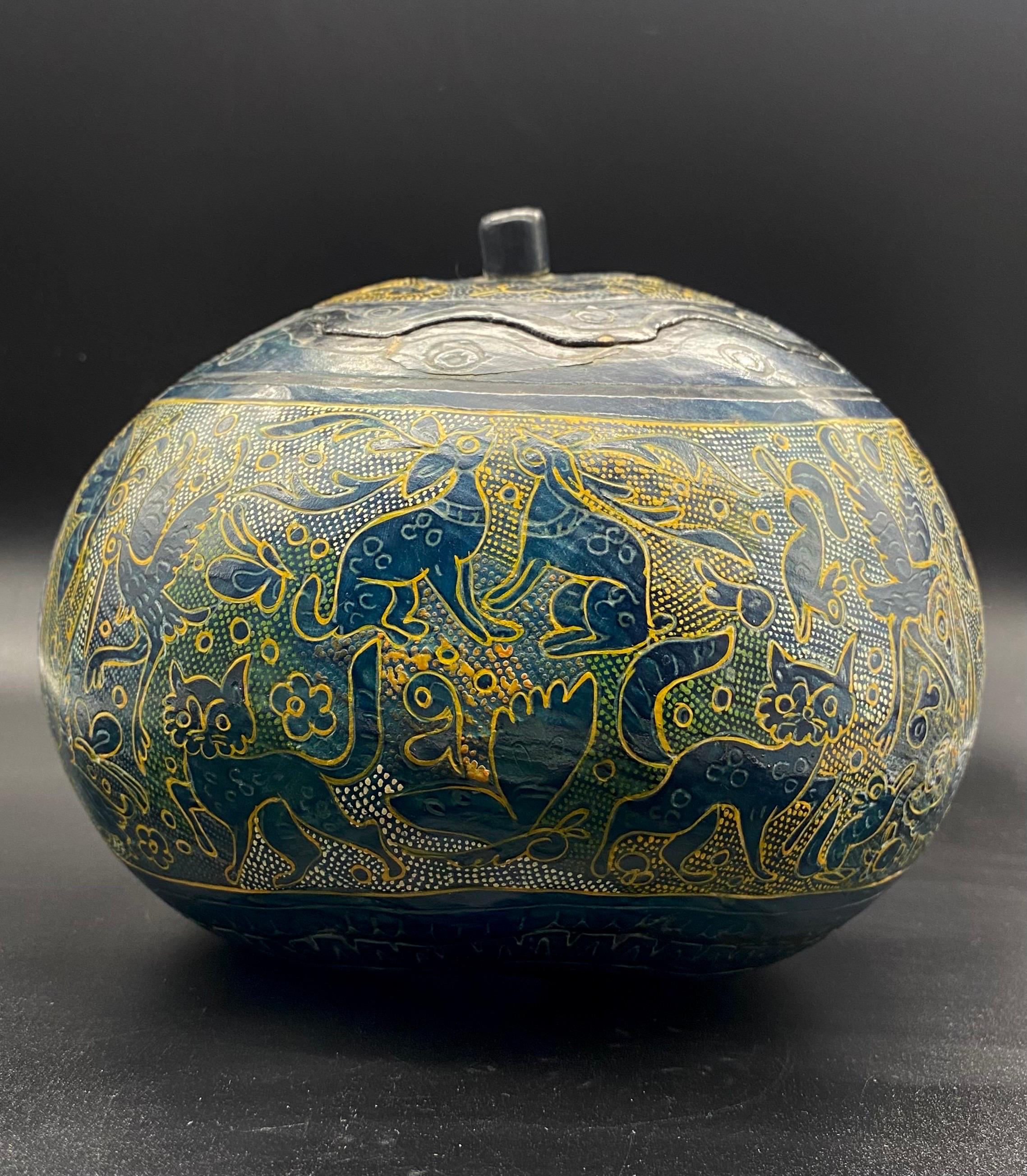 Beautiful lacquered paper mache box decorated with imaginary animals (that look like cats) and plant motifs.
The box seems to take the shape of a vegetable or cucurbit / gourd.
The paper mache (or boiled cardboard) is painted black (with dark blue