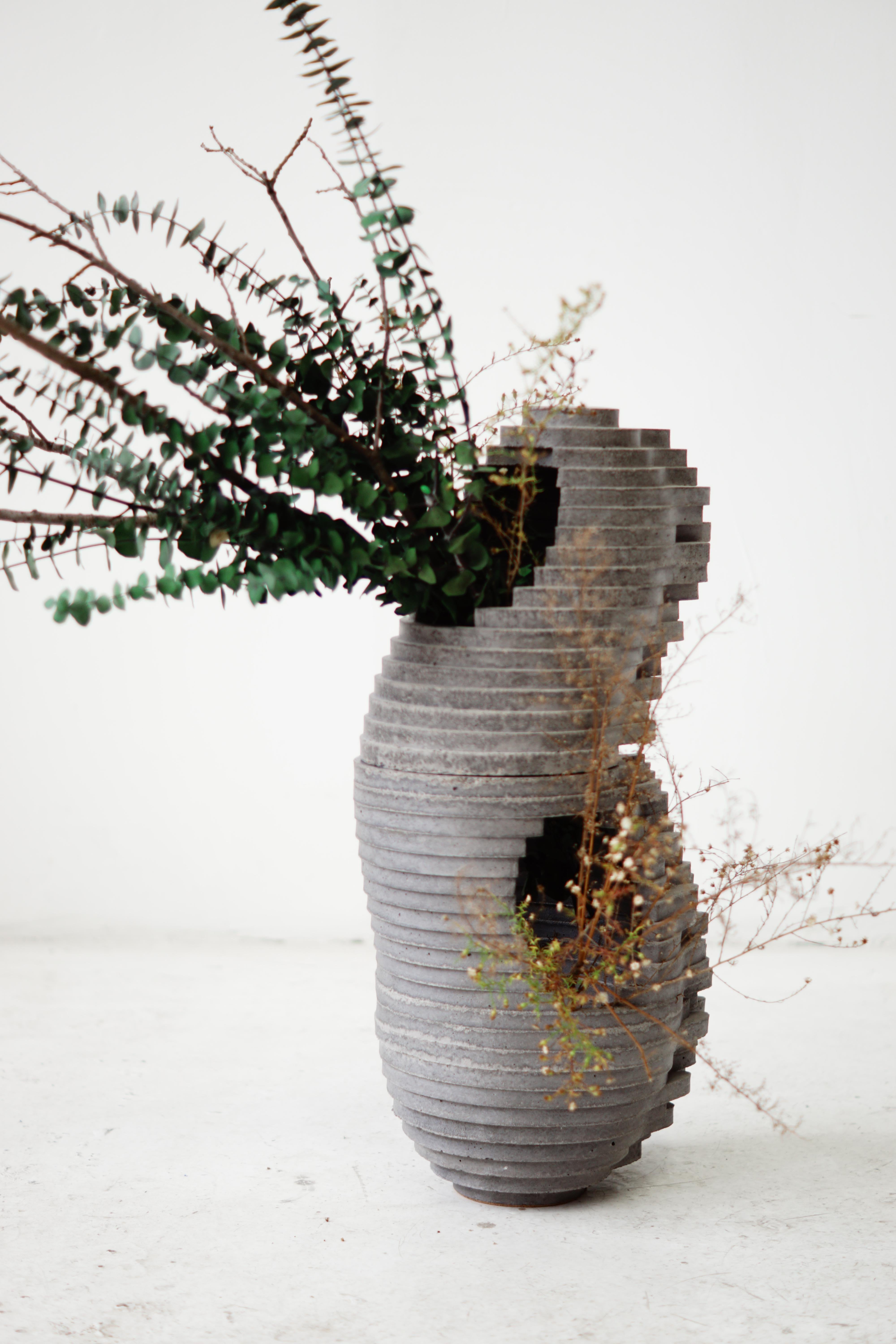 Vaso in stile Ikebana, fuso a mano in due parti per uso interno ed esterno.

All'incrocio tra arte, artigianato e design, la collezione di debutto di Concrete Poetics, composta da mobili e accessori scultorei in cemento fuso a mano, presenta forme