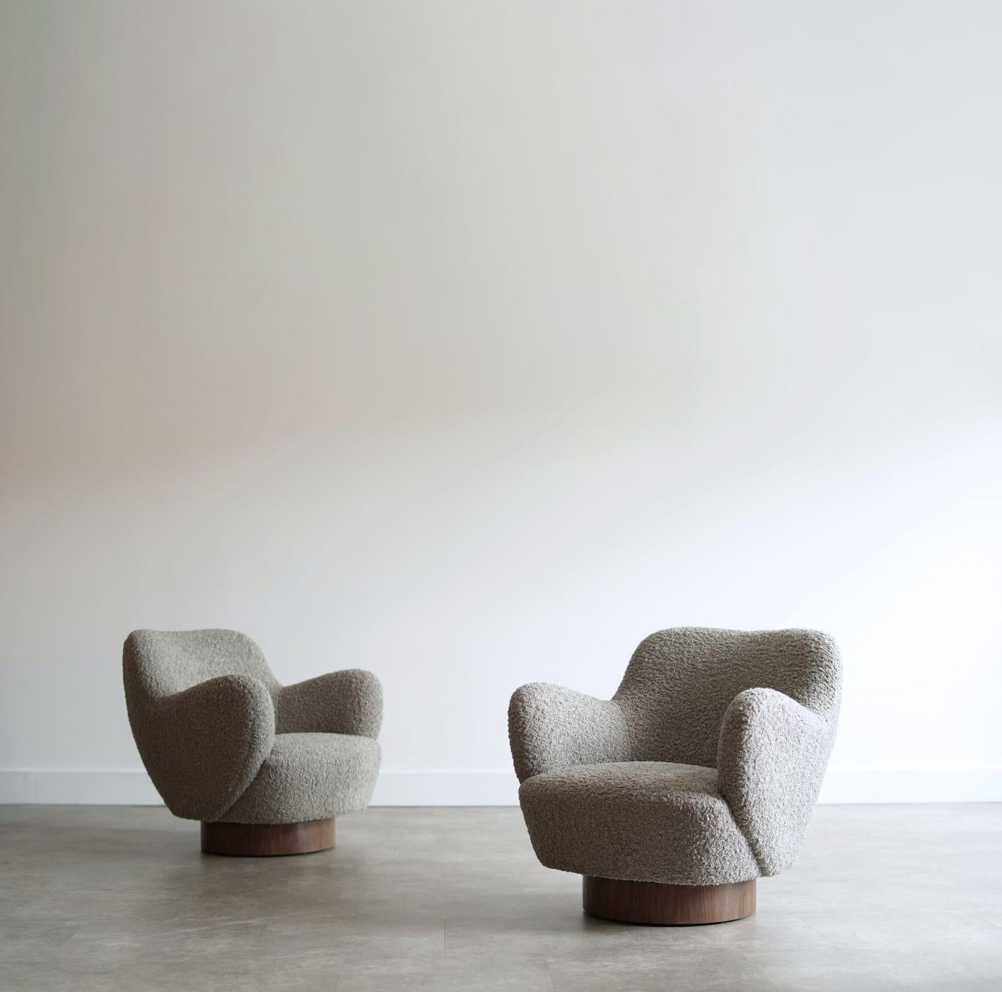 Set of swivel chairs designed by Vladimir Kagan during his Kagan-Dreyfuss partnership in the 1960s. Fully restored by Stamford Modern, these sculptural chairs are reupholstered in a rich gray bouclé, offering both comfort and elegance. The walnut