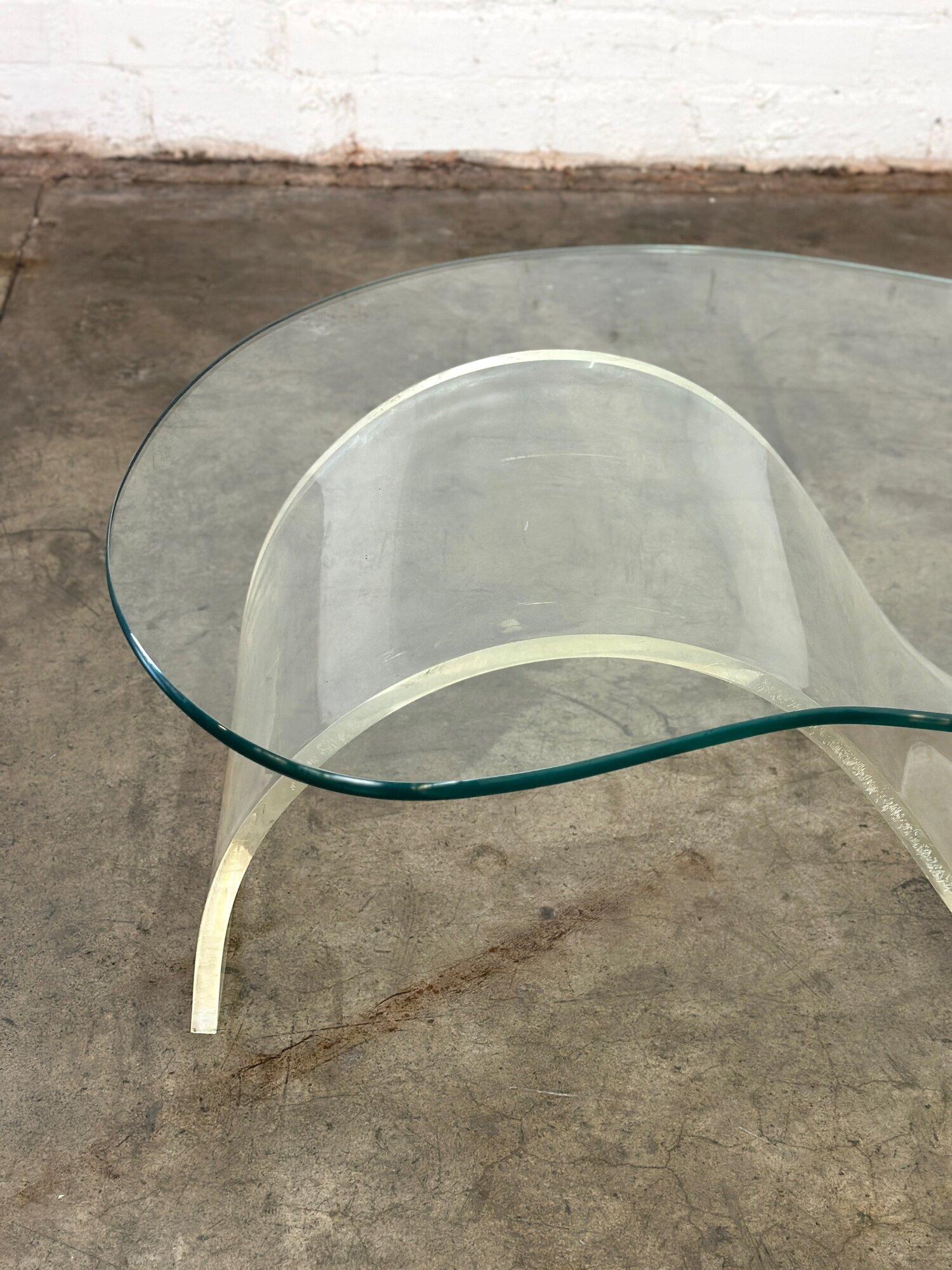 W50 D27 D24 D27 H15

Post Modern Biomorphic coffee table in the style of Vladimir Kagan. Table features a biomorphic glass top and a serpentine shaped lucite base. Item is in overall good vintage condition with some signs of wear. 