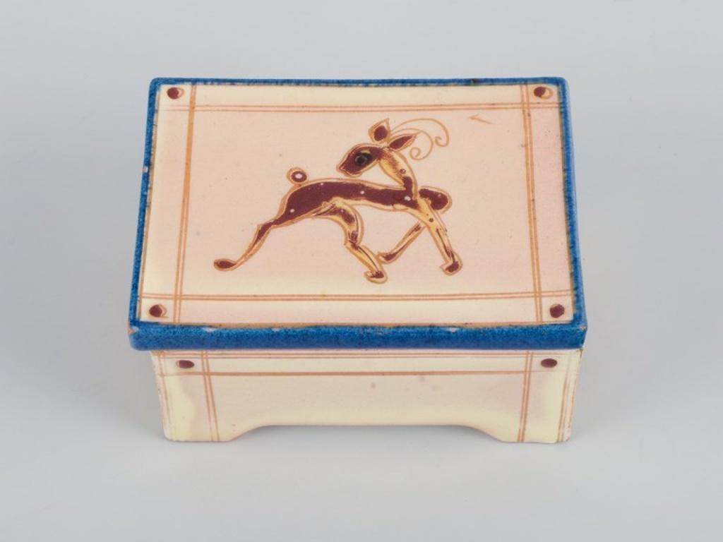 Kähler, eine Miniaturvase und ein Behälter mit Deckel. Handdekoriert.
1940s.
Markiert.
Behälter mit Deckel: L 9,0 cm x H 4,0 cm.
Miniatur-Vase: H 5,0 cm.