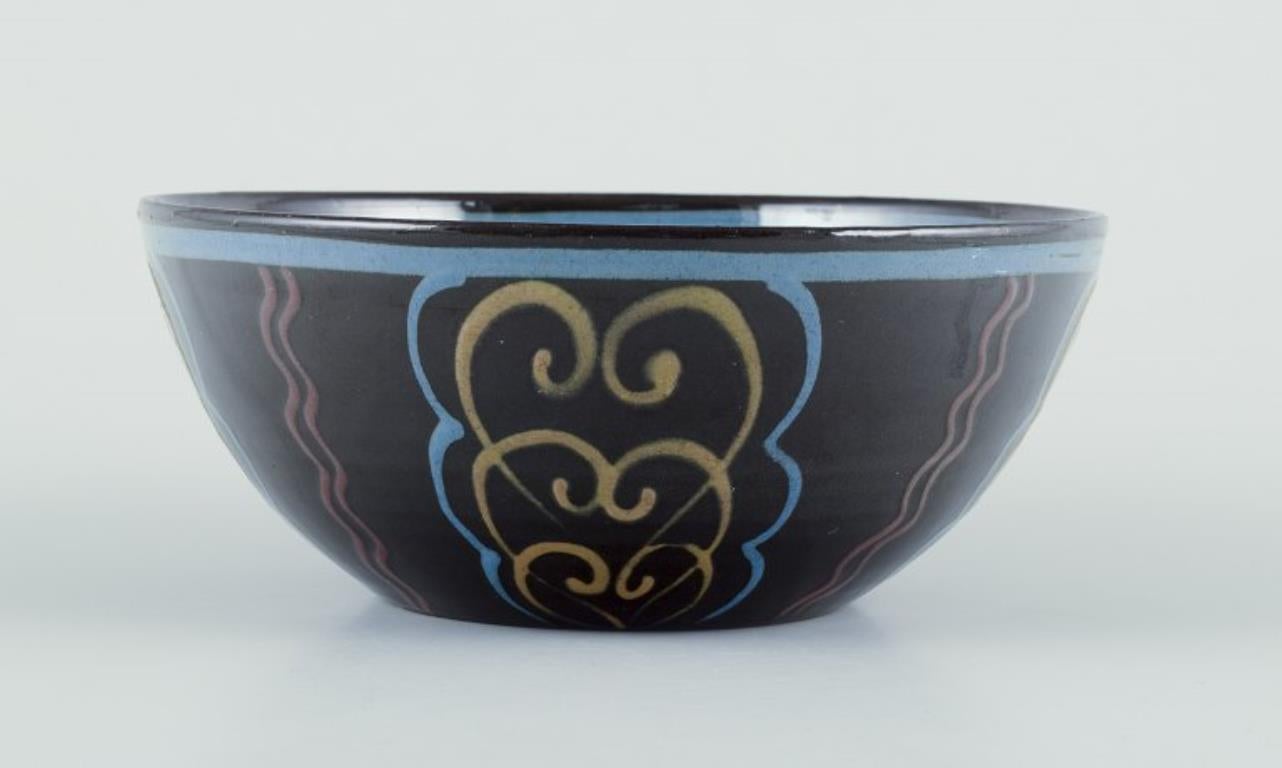 Kähler, Denmark. Ceramic bowl.
Polychrome glaze on a black base.
Circa 1930s. 
Marked.
Perfect condition.
Dimensions: D 16.5 cm. x H 7.0 cm.