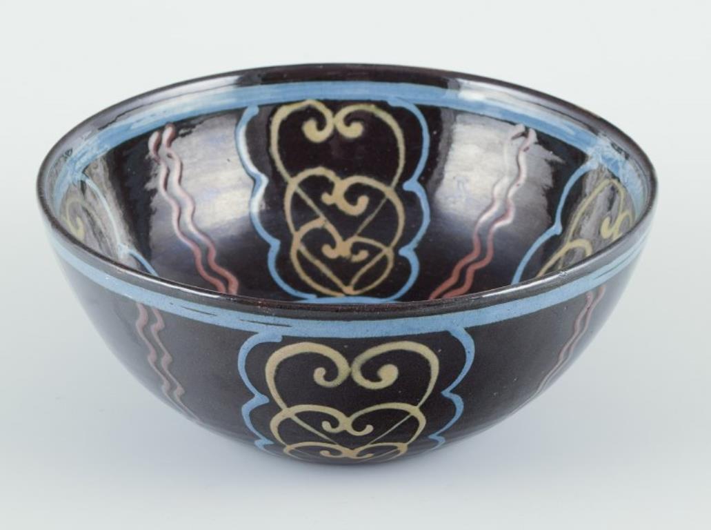 Danish Kähler. Ceramic bowl. Polychrome glaze on a black base. Circa 1930s. For Sale