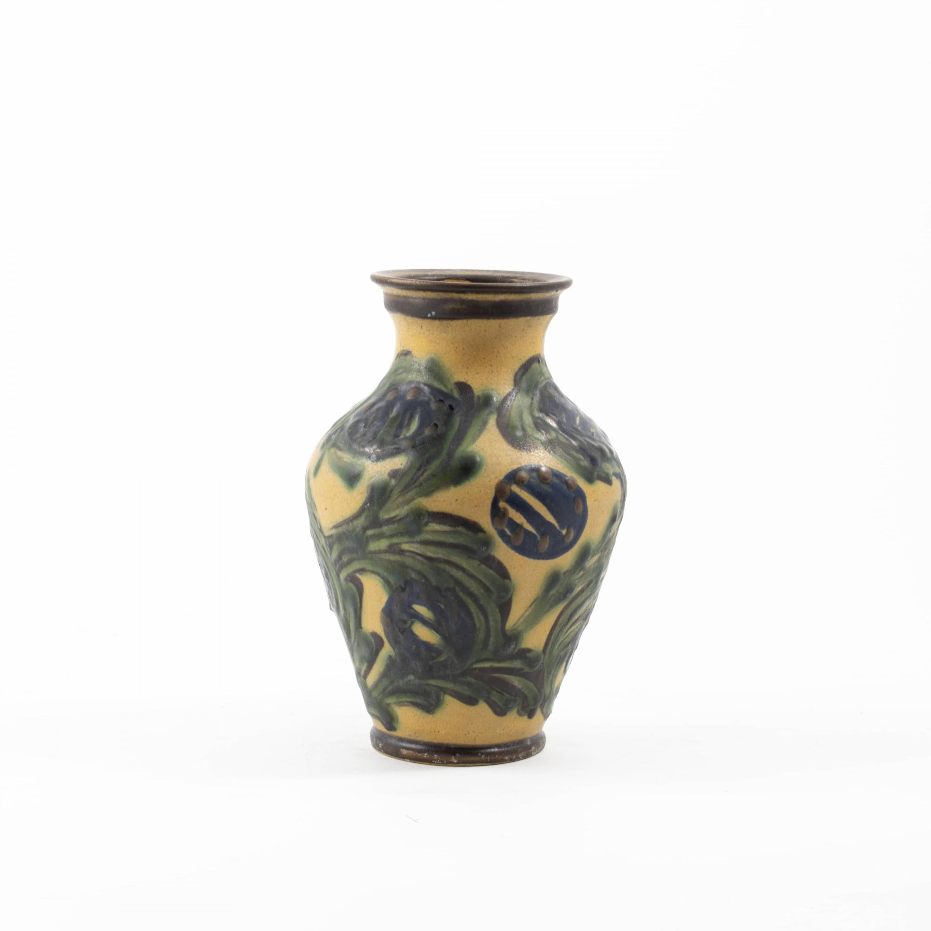 Kähler ceramic vase.
Polychrome matt glaze with leaf work on a yellow base.

Signed: HÄK (Herman A. Kähler).
