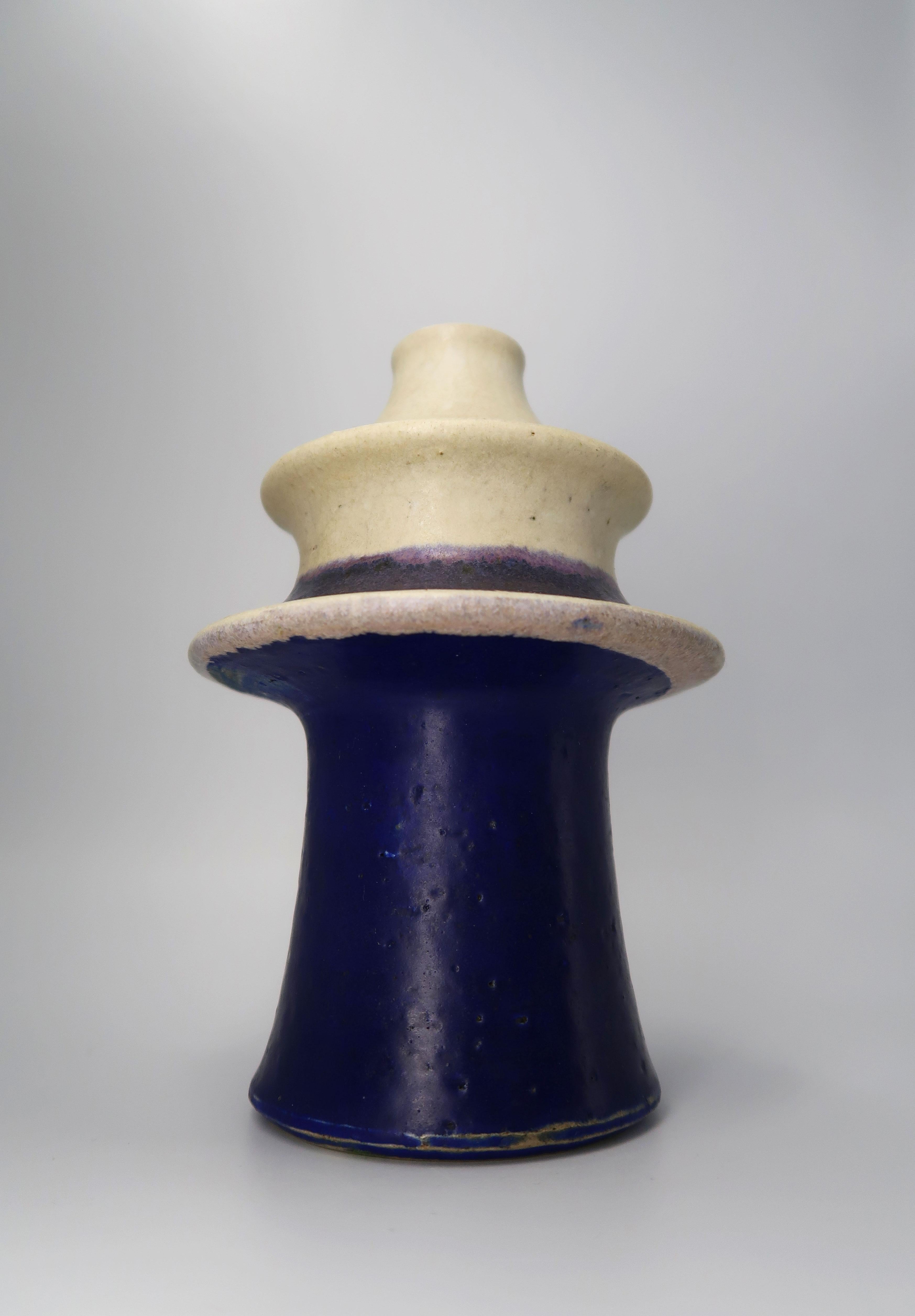 Handmade Danish Mid-Century Modern tiered ceramic vase by British ceramic artist Carl Cunningham-Cole for acclaimed Danish ceramic manufacturer Kähler. Warm beige colored glaze on top with cobalt blue glaze on the bottom and lilac, dark purple and