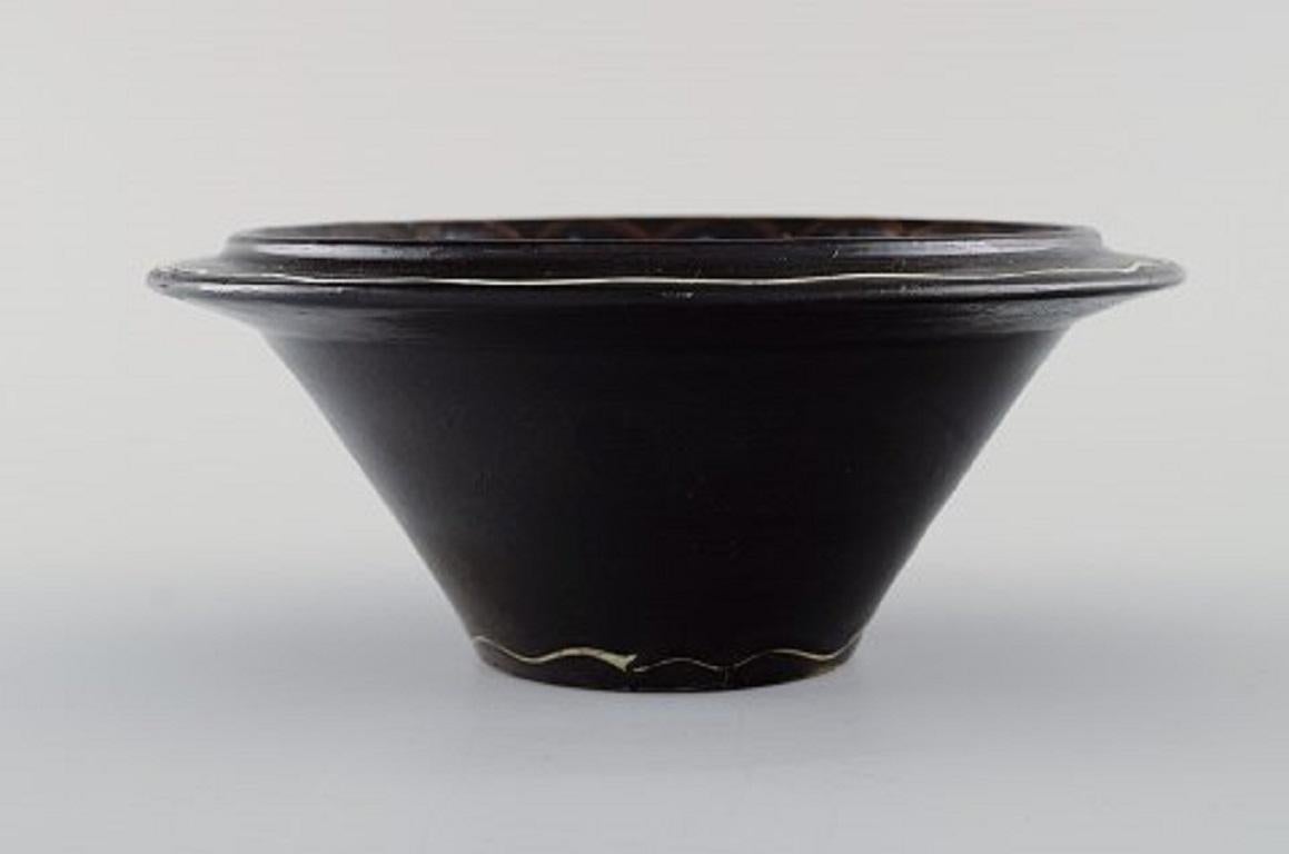 Kähler, Denmark. Bowl in black glazed ceramics with blue and white waves along the edge, 1930s-1940s.
Measures: 17 x 7 cm.
In very good condition.
Signed.
