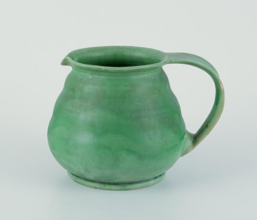 Kähler, Denmark. Ceramic pitcher.
Glaze in green tones.
Approximately 1930/40s.
Marked.
In excellent condition with a minimal glaze defect on the handle. See photo.
Dimensions: Height 12.0 cm x Diameter 17.0 cm including handle.