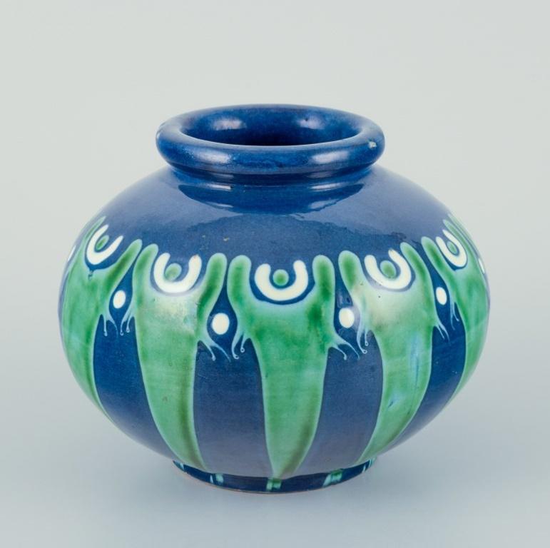 Kähler, Denmark. Ceramic vase. 
Cow horn glaze/technique in blue and green tones.
Approximately 1930s.
Marked.
In excellent condition.
Dimensions: Height 10.5 cm x Diameter 12.5 cm.

