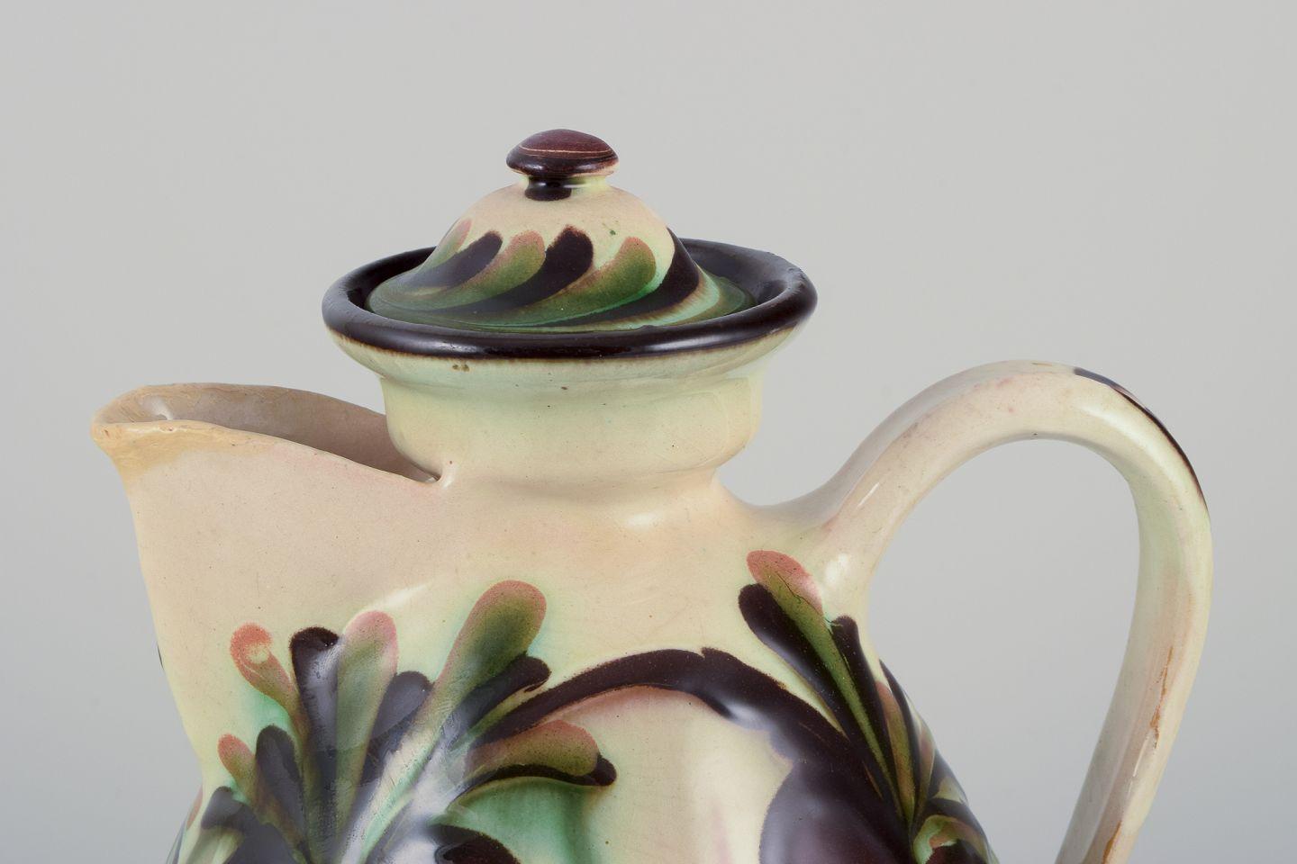 Pre-owned goods are exempt from import duties for U.S. customers. 
Therefore, no import tariffs will be applicable to your purchase.

Kähler, Denmark. Chocolate jug made of ceramic decorated with polychrome glaze.
Floral motifs on a cream-colored